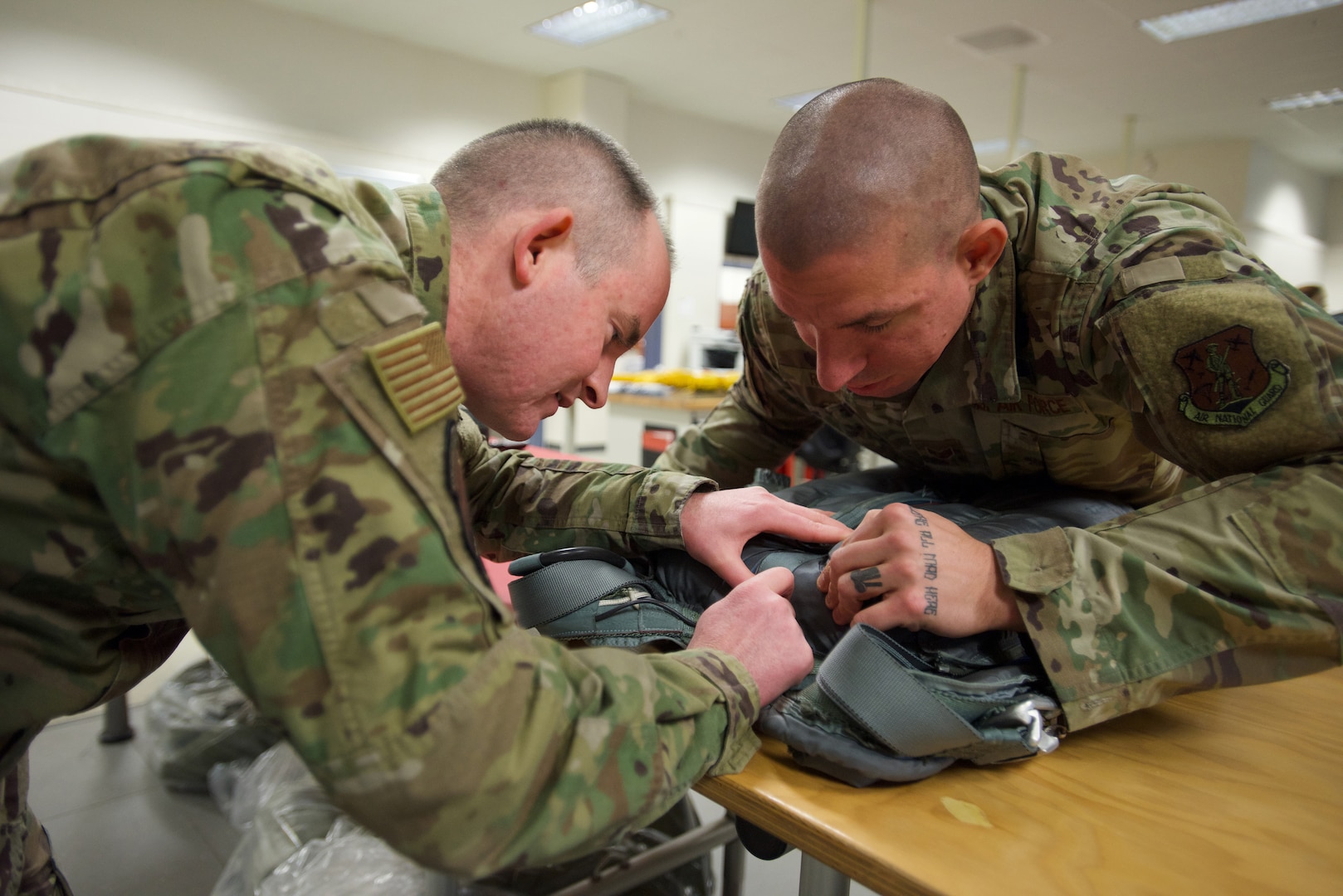 Alaska Air National Guard Master Sgt. Sam Cooper, left, 176th Operations Support Squadron Aircrew Flight Equipment Flight chief, C-17 Globemaster III Section, and Alaska Air National Guard Staff Sgt. Joseph Rotar, a C-17 AFE technician, work on a BA-22 bailout kit parachute Jan. 15, 2020, at Joint Base Elmendorf-Richardson, Alaska. AFE technicians work on dozens of pieces of equipment necessary for C-17 aircrew survival and life support.