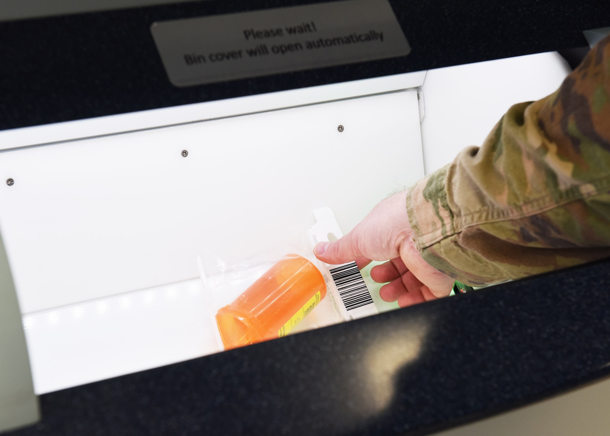 Staff Sgt. Dustin Stevens, 7th Medical Support Squadron pharmacy technician, picks up a test prescription bottle out of the ScriptCenter at Dyess Air Force Base, Texas, Feb. 26, 2020.