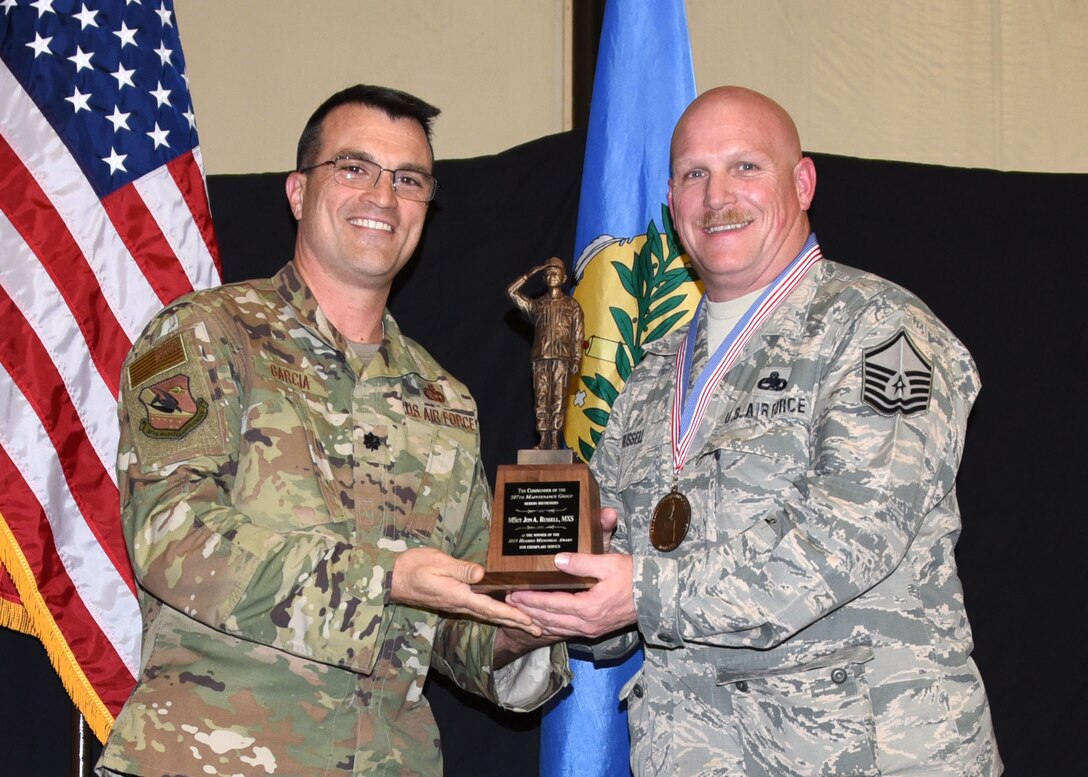 Master Sgt. Jon Russell, 507th Maintenance Squadron, receives the 2019 507th Maintenance Group Billy Hughes Memorial Award from Lt. Col. Bradley Garcia, 507th MXG vice commander, during the 2019 Annual Awards Banquet Feb. 8, 2020, at Tinker Air Force Base, Oklahoma. (U.S. Air Force photo by Tech. Sgt. Samantha Mathison)