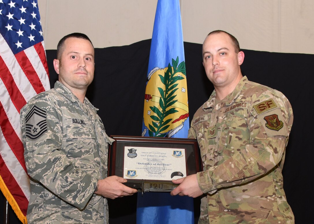 Tech. Sgt. Justin Jarrett, 507th Security Forces Squadron defender, receives the 2019 Defender of the Year award, presented by Chief Master Sgt. James Bolling, 507th SFS, during the 2019 Annual Awards Banquet Feb. 8, 2020, at Tinker Air Force Base, Oklahoma. (U.S. Air Force photo by Tech. Sgt. Samantha Mathison)