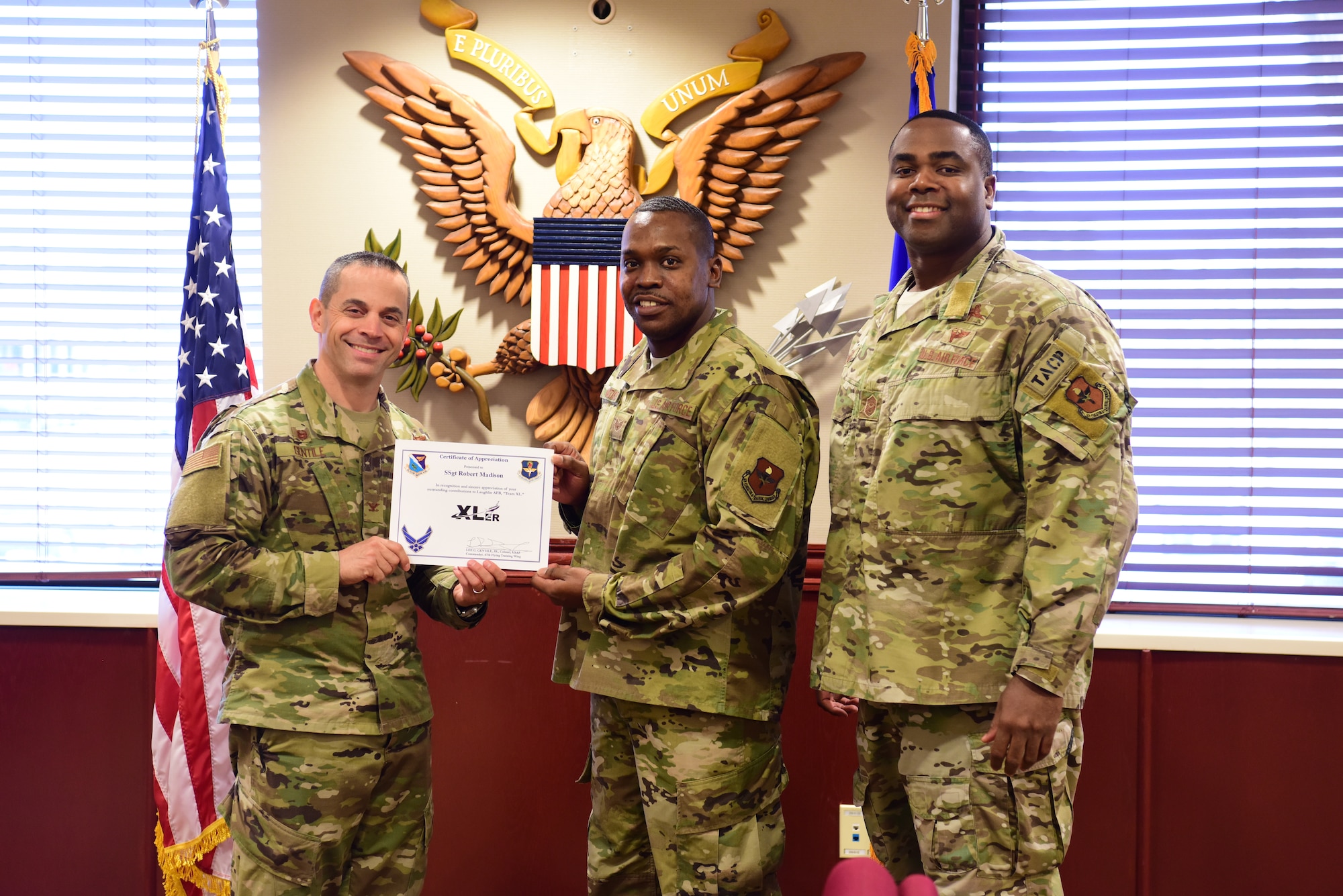 Staff Sgt. Robert Madison, 47th Flying Training Wing NCO in charge of wing administration, accepts the “XLer of the week” award from Col. Lee Gentile, the 47th Flying Training Wing Commander, and Chief Master Sgt. Robert L. Zackery III, 47th FTW command chief master sergeant, on Feb. 14, 2020 at Laughlin Air Force Base, Texas. The “XLer of the Week” award is given to those who consistently make outstanding contributions to their unit and the Laughlin mission. (U.S. Air Force photo by Senior Airman John A. Crawford)