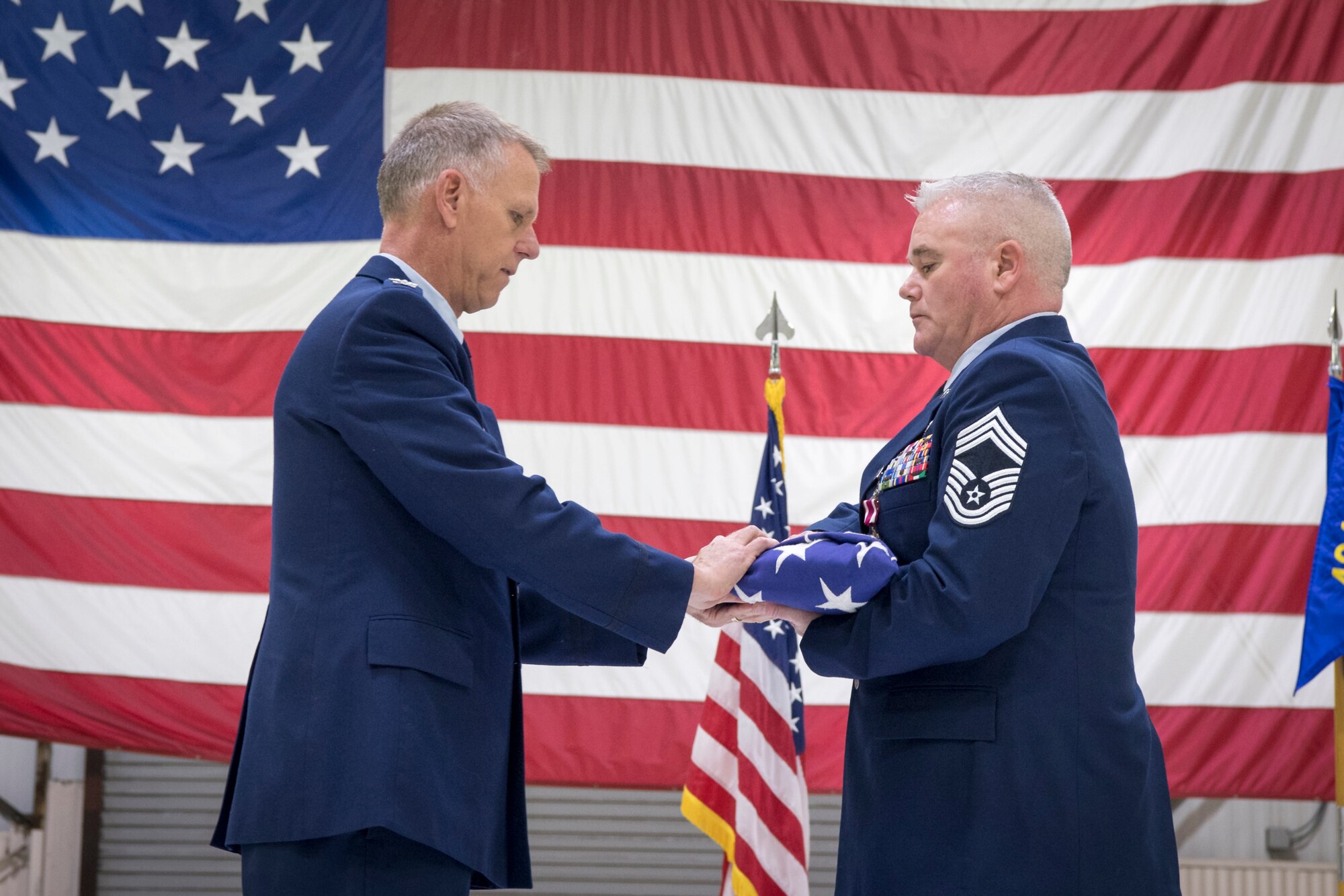 Chief Master Sgt. James Hambruch, 434th Aircraft Maintenance Squadron assistant superintendent, receives a folded American flag from Col. Larry Shaw, 434th Air Refueling Wing commander, during his retirement ceremony at Grissom Air Reserve Base, Indiana, Feb. 08, 2020. The flag was folded during a ceremony honoring the chief’s patriotic 34-year career in the armed forces. (U.S. Air Force photo/Master Sgt. Ben Mota)