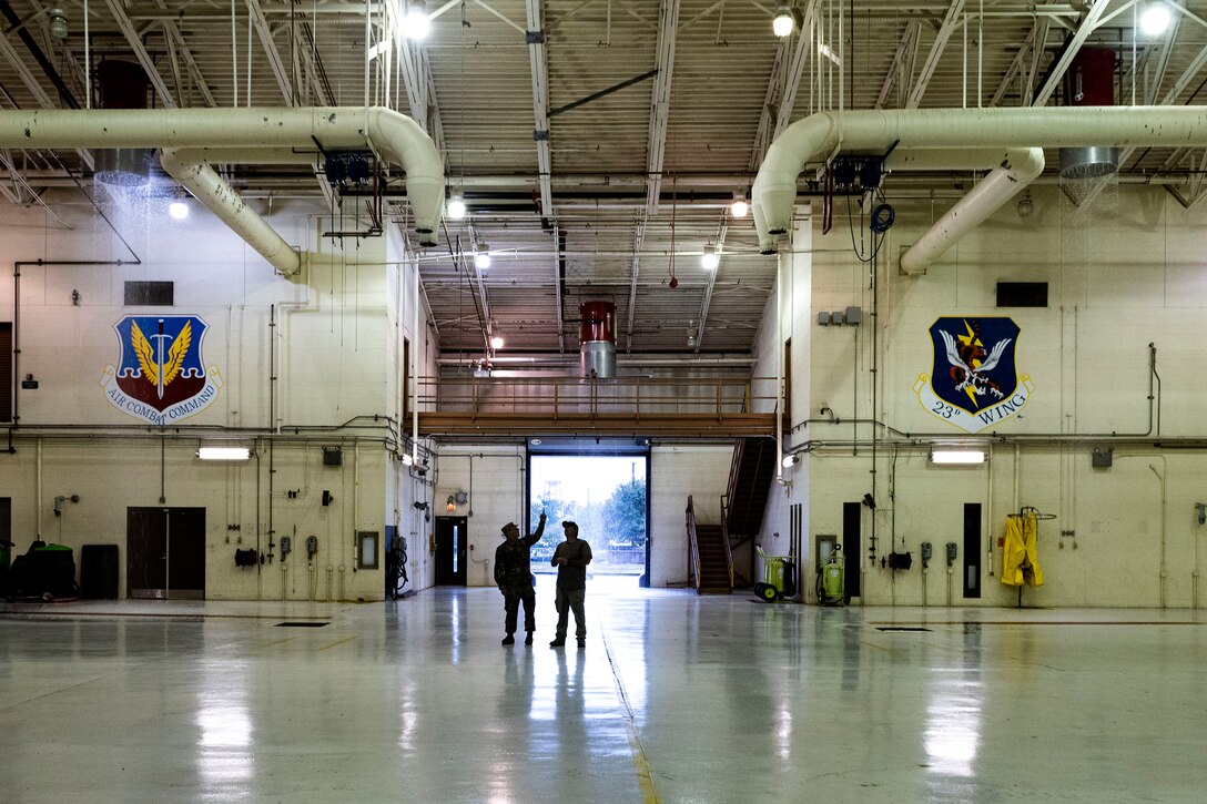 Photo of Airmen examining a foam suppression system.