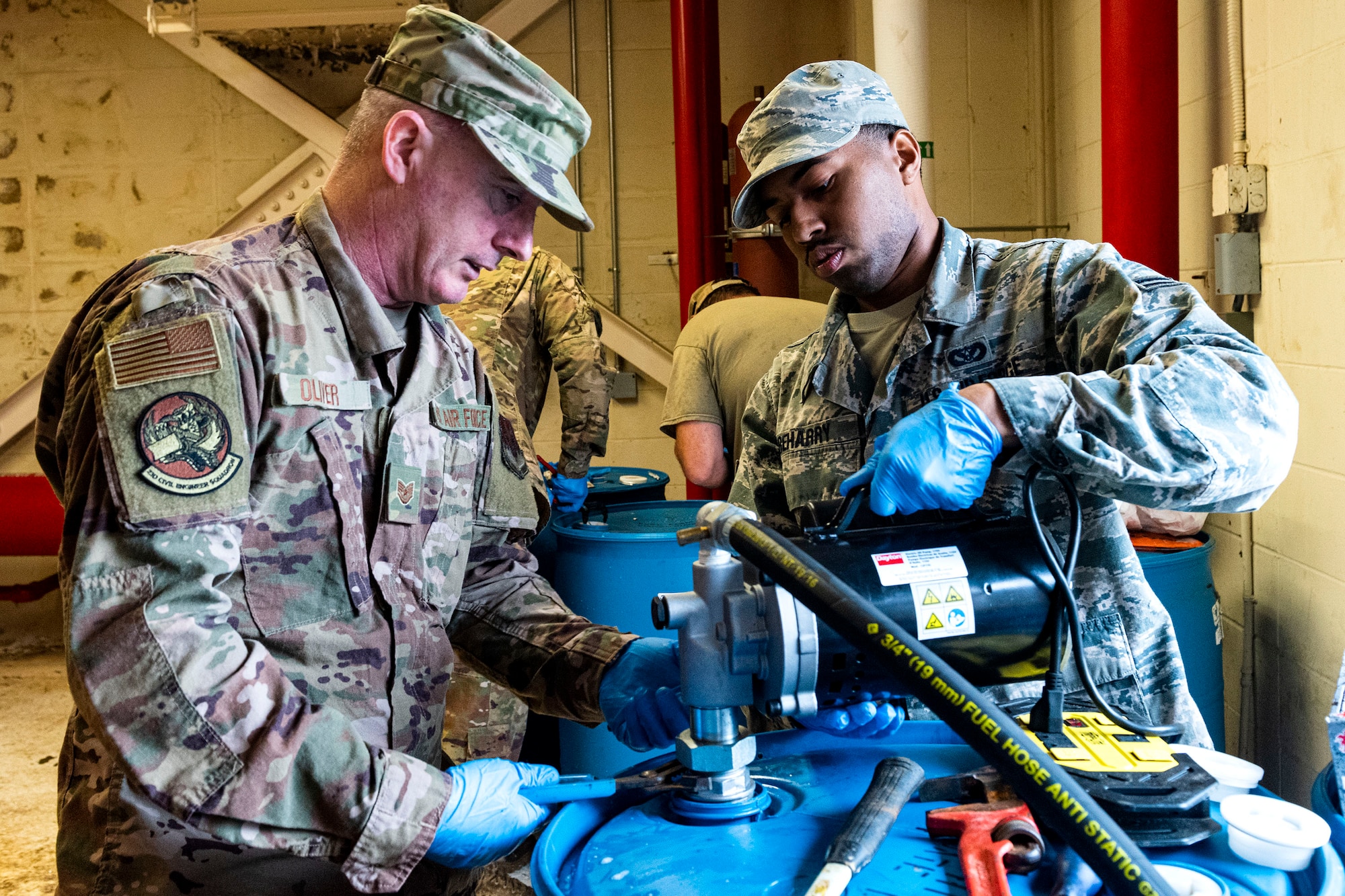 Photo of Airmen removing a transfer pump.