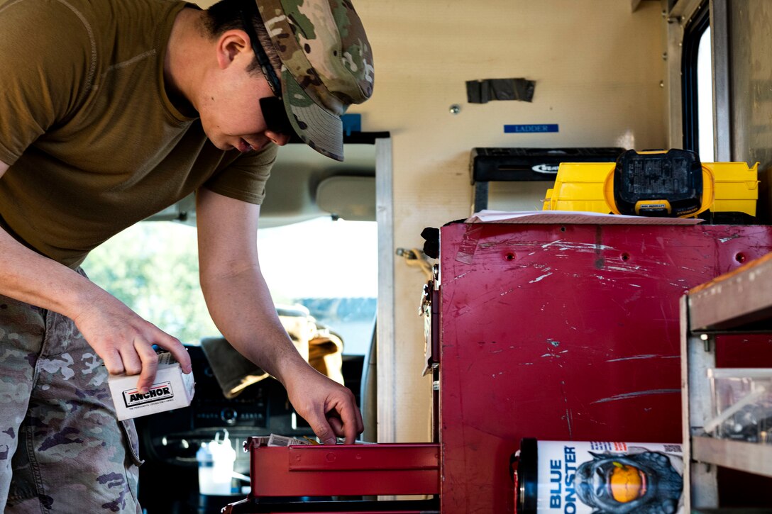 Photo of Airman looking for drill bits.