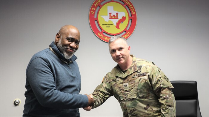 Brooks Hubbard, public affairs specialist from USACE Los Angeles District receives a commander's coin for his work on the Coastal Protection and Restoration Feasibility Study during his 149 day duty to the Galveston District.