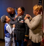 Husband Chris Price, son Jeremiah and mother, Doris Dorsey, pin the rank of Lieutenant Colonel on Danielle Price during a ceremony Feb. 27 at the Illinois State Military Museum, Springfield, Illinois.