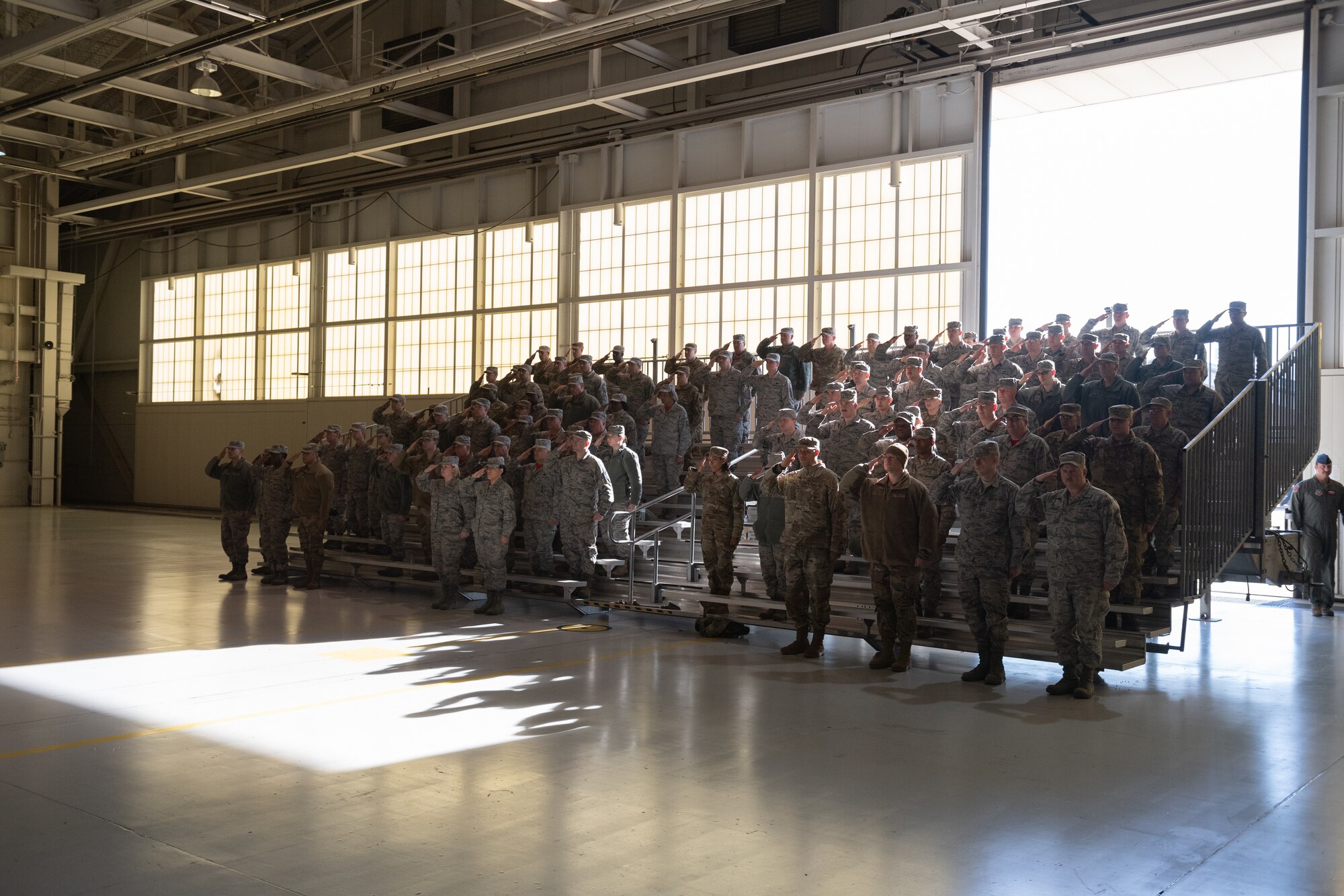 A group of Airmen salutes at a ceremony