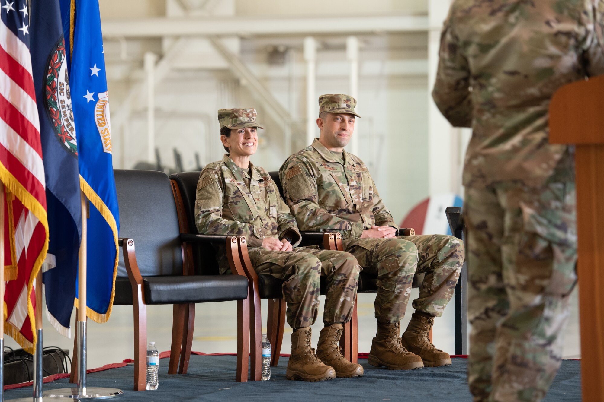 two officers seated on stage