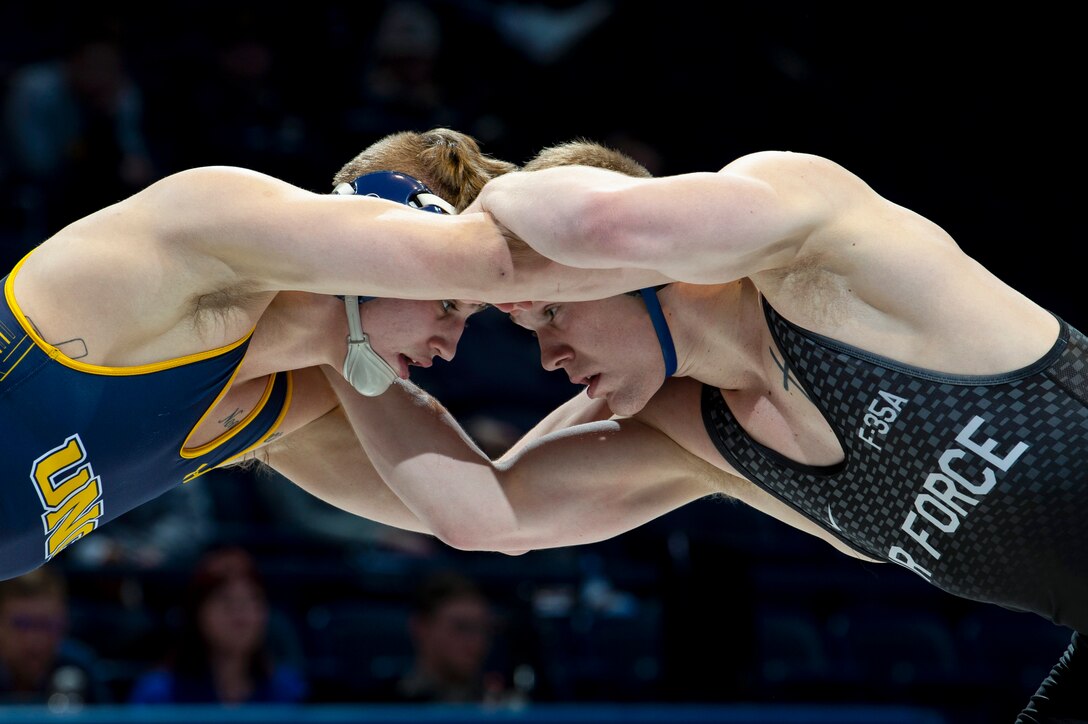 A U.S. Academy Air Force wrestler lock arms with a competitor.