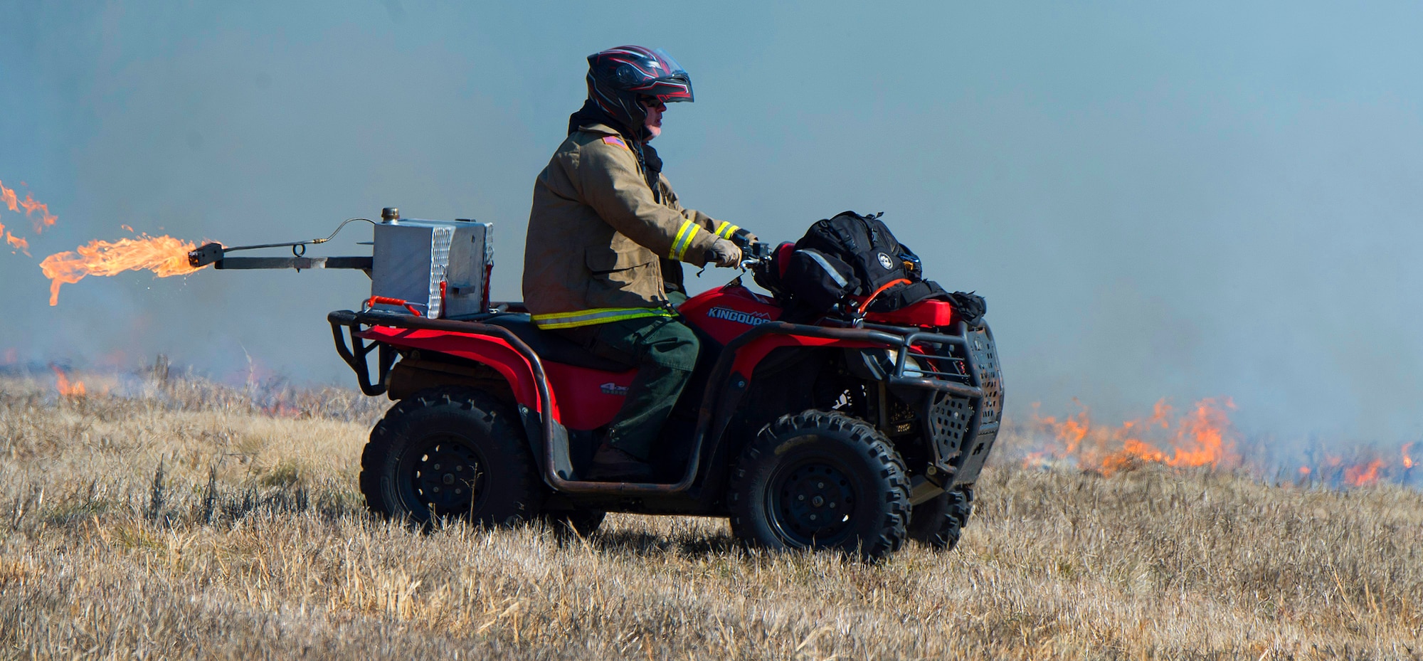 Steven Holmes, Air Force Wildland Fire Branch Wildland Support Module lead, uses an all-terrain vehicle, Feb. 21, 2020, rigged with an automatic drip torch to spread fire across an Air Force-owned plot of land near the Northern boundary of Wright-Patterson Air Force Base, Ohio. The wildland support module, out of Joint Base McGuire-Dix-Lakehurst, N.J., travels the Eastern United States setting controlled fires mostly with the goal of reduce hazardous fuel levels to minimize the threat of brush and forest fires to Air Force installations and personnel.  (U.S. Air Force photo/R.J. Oriez)