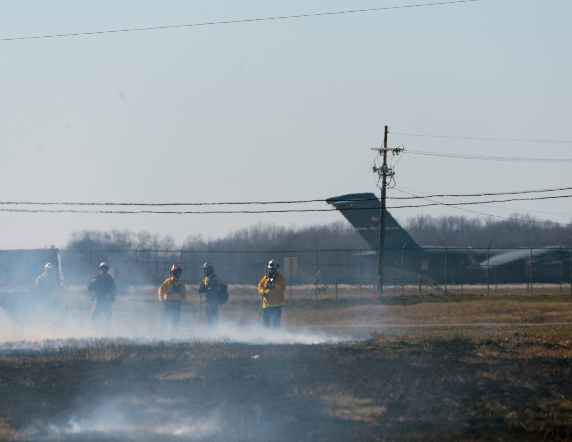 Members of the Air Force Wildland Fire Branch Wildland Support Module and the Wright-Patterson Air Force Base, Ohio, Fire Department, part of the 788th Civil Engineer Squadron, look out over scorched earth at the end of a prescribed burn near the base Feb. 21, 2020. The patch of Air Force-owned land is in the base’s glide scope and clear zone so it is the 88th Civil Engineering Group Natural Resource Program Office’s responsibility to manage. (U.S. Air Force photo/R.J. Oriez)