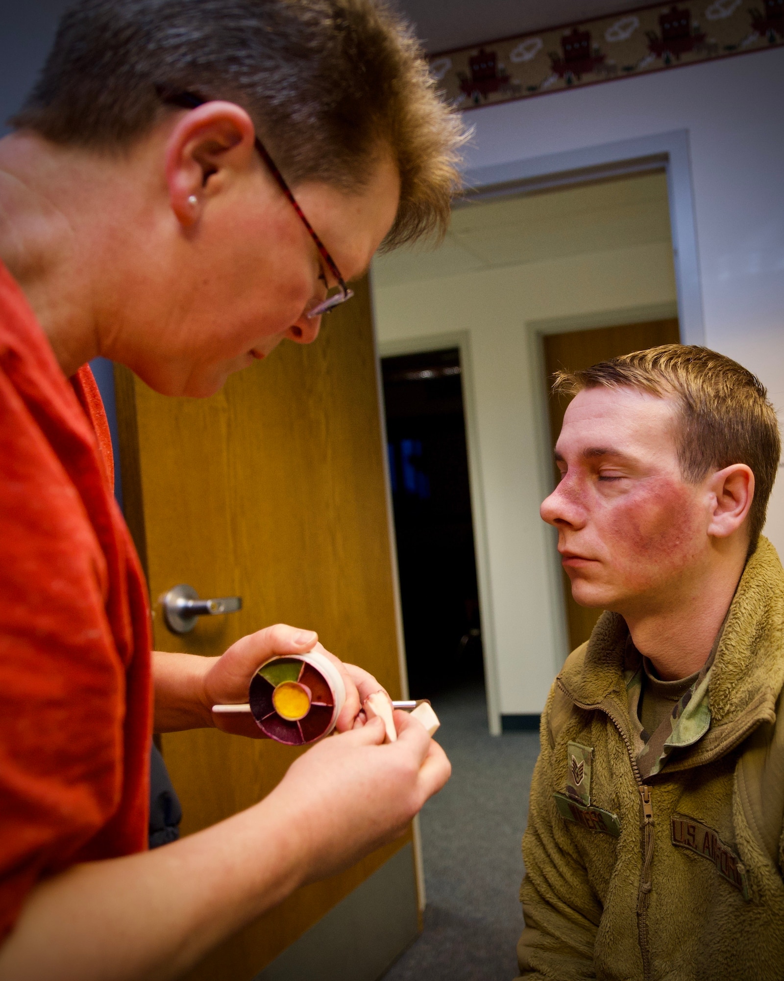 Staff Sgt. Adam Waters has makeup applied to his face during the Black Eye Campaign, Feb. 25. Waters wore the makeup all day in his work area to simulate intimate partner violence. (U.S. Air Force photo by Jennifer Spradlin)