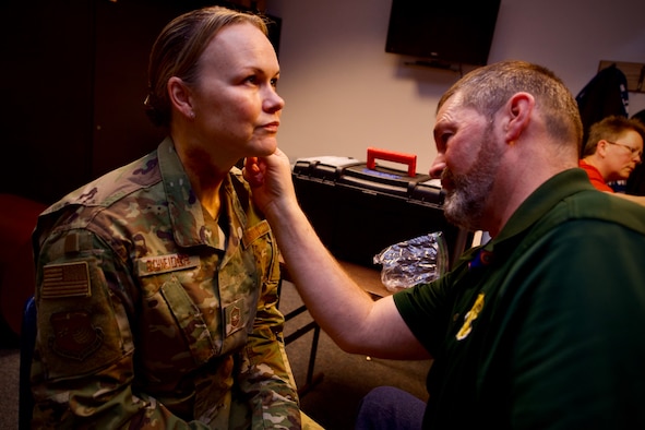 Senior Master Sgt. Candi Schneider, the 10th Force Support Squadron, has makeup applied to her face and neck to simulate abuse-related injuries for the Black Eye Campaign, Feb. 25. Schneider, a domestic abuse survivor, said the exercise led to important conversations in her unit about how to respond to intimate partner violence as Air Force leaders.