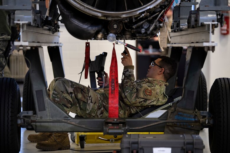 Airman inspects internal components of a jet engine using a borescope