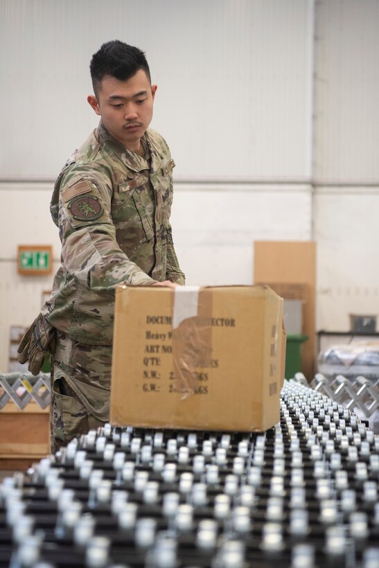 Airman 1st Class James Shin, 100th Logistics Readiness Squadron in bound cargo specialist, slides a package across a conveyor Feb. 27, 2020, at RAF Mildenhall, England. Traffic management and material management Airmen work side-by-side within in bound cargo to process incoming aircraft parts, equipment and other mission essential assets. (U.S. Air Force photo by Airman 1st Class Joseph Barron)
