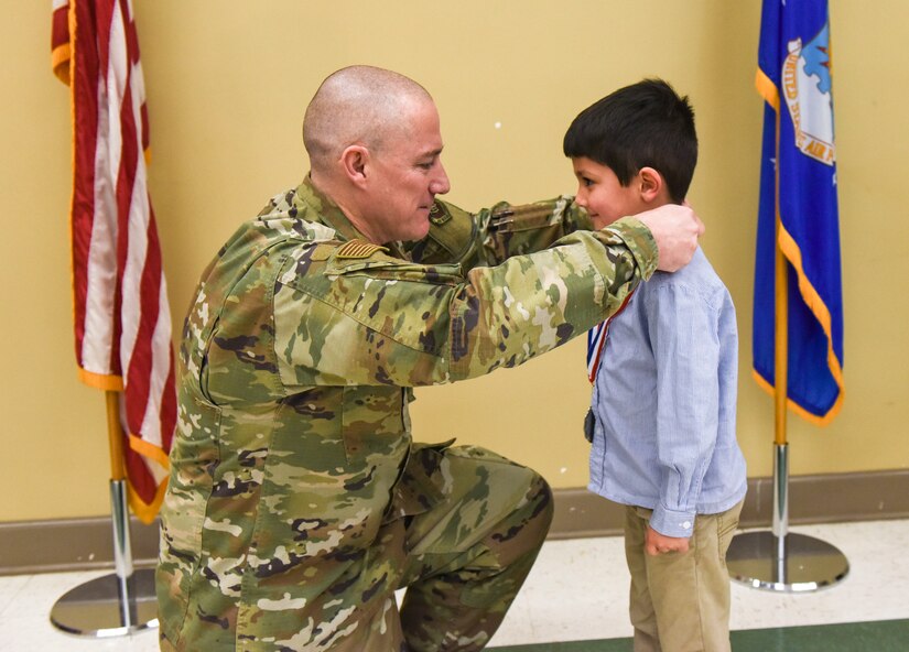 Chief Master Sgt. Ronnie Phillips, 437th Airlift Wing command chief, places a medal on Kamden Alshaikhly, "Little Hero”, at Joint Base Charleston, S.C., Feb. 27, 2020.