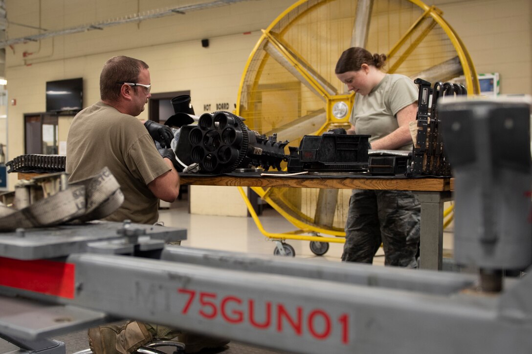 A photo of Airmen inspecting an A-10 gun system.