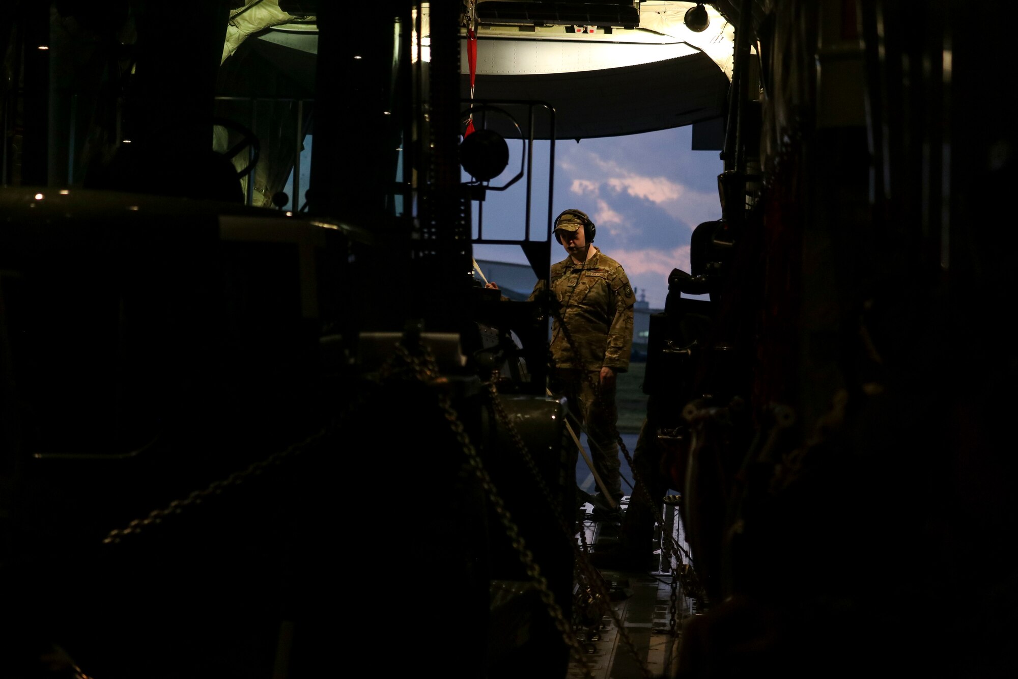 A loadmaster with the 41st Airlift Squadron completes a preflight inspection of cargo prior to taking off during an Agile Combat Employment experiment at Kadena Air Base, Japan.