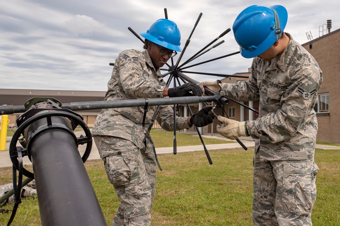 Two airmen set up a communication device.