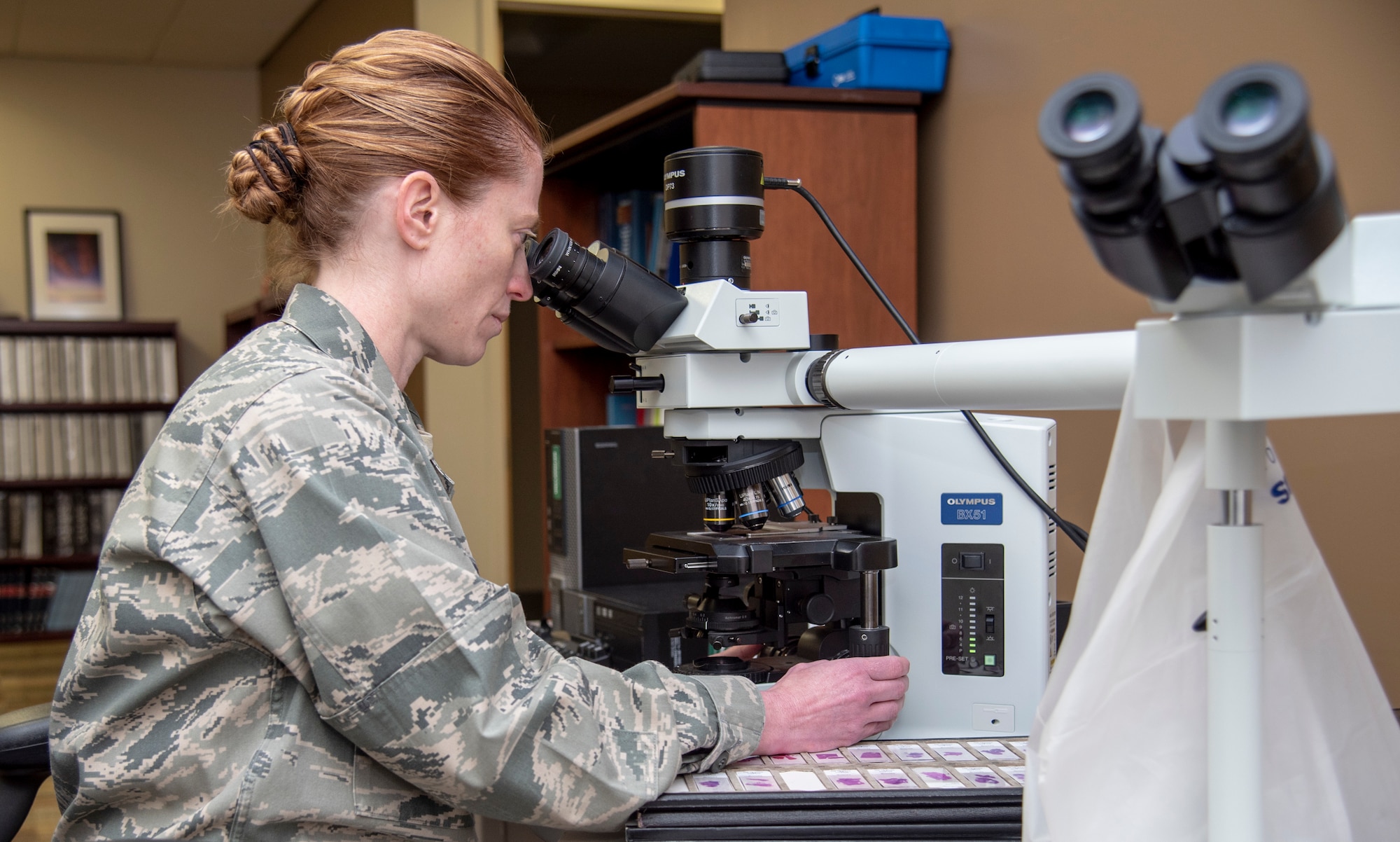 U.S. Air Force Lt. Col. Alice Briones, Armed Forces Medical Examiner System deputy director, looks at histology slides under a microscope June 7, 2018, at Dover Air Force Base, Delaware. Briones joined AFMES as deputy medical examiner in Rockville, Maryland in 2010, and Dover AFB, Delaware, and was appointed director of the DoD DNA Registry in 2014, coordinating services in both the Armed Forces Repository of Specimen Storage for Identification of Remains and the Armed Forces DNA Identification Laboratory. (U.S. Air Force photo by Staff Sgt. Nicole Leidholm)