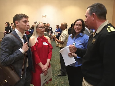 IMAGE: FREDERICKSBURG, Va. (Feb. 25, 2020) – Capt. Casey Plew, Naval Surface Warfare Center Dahlgren Division (NSWCDD) commanding officer, and Susan Tubman, NSWCDD Staffing and Classification Branch head discuss career opportunities with candidates at the fourth annual NSWCDD Career Fair. The command made 33 on-the-spot job offers at the event held in the Fredericksburg Expo and Conference Center. In all, 308 candidates attended the career fair where they interviewed for NSWCDD positions available for entry-level and experienced scientists, engineers, and business professionals. (U.S. Navy photo/Released)