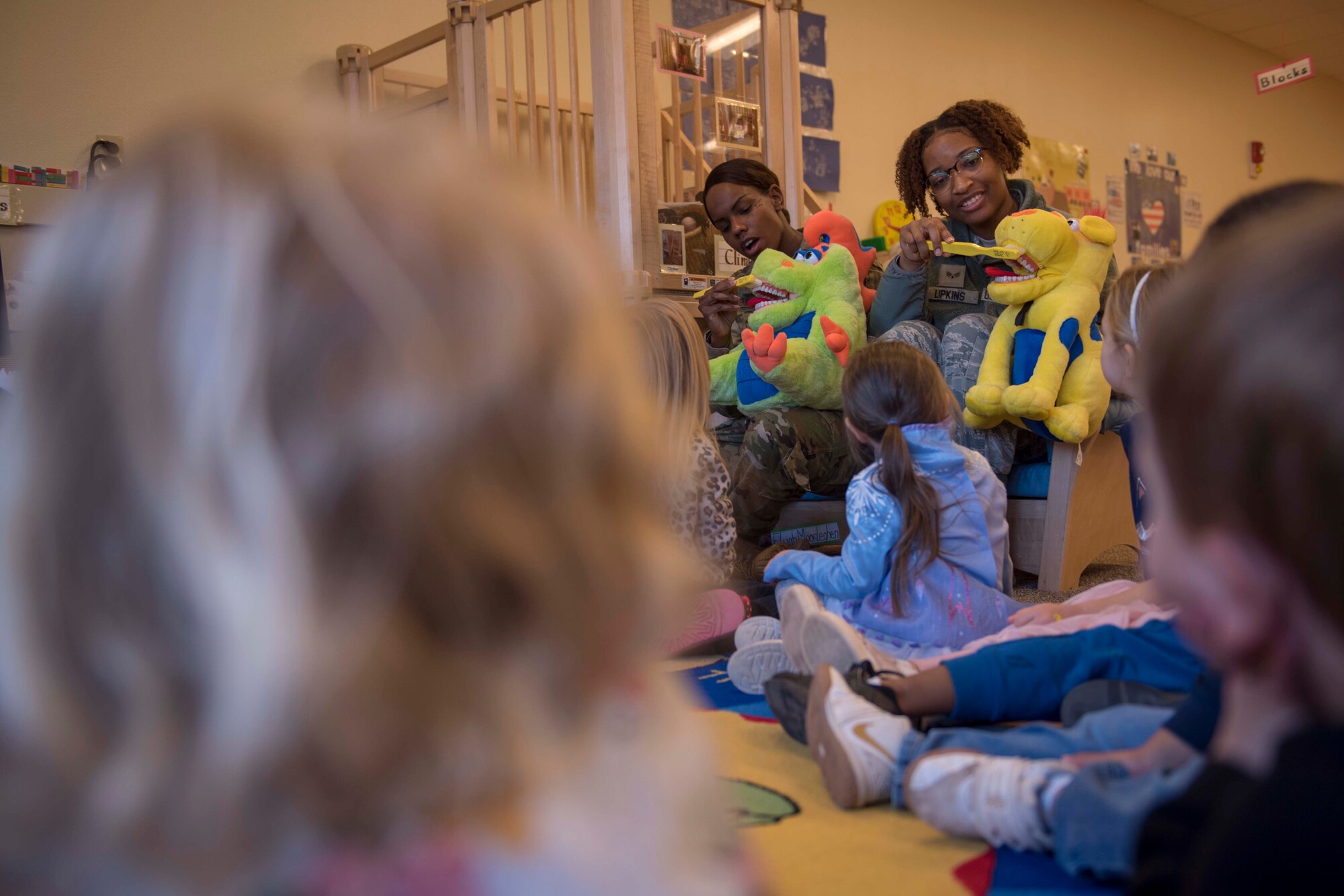 Senior Airman Juanita Black, left, and Senior Airman Brian Lipkins, both 49th Operational Readiness Medical Squadron  dental technicians, demonstrate to children proper brushing techniques, Feb. 11, 2020, at the Holloman Child Development Center on Holloman Air Force Base, N.M. The dental flight visits children across base annually, as part of Children’s Dental Health Month, to educate them and their caregivers on the importance of dental hygiene. (U.S. Air Force photo by Staff Sgt. Christine Groening)