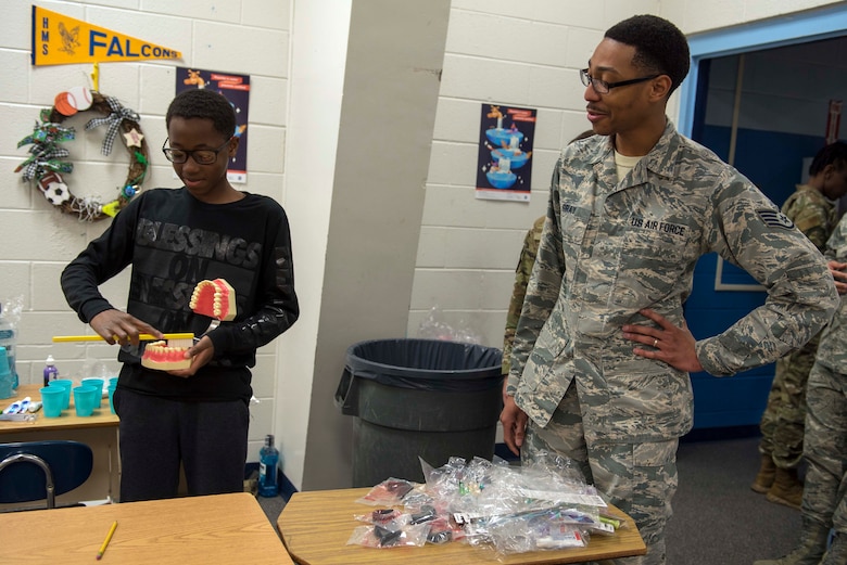 Staff Sgt. Desmond Gray, 49th Operational Readiness Medical Squadron Dental Flight technician, watches as a Holloman Middle School student demonstrates his brushing technique on a fake set of teeth, Feb. 26, 2020, on Holloman Air Force Base, N.M. Between dental visits it’s recommended to check for tooth sensitivity, pain when eating or drinking, bleeding gums, holes or pits in teeth, discoloration or bad breath. (U.S. Air Force photo by Staff Sgt. Christine Groening)
