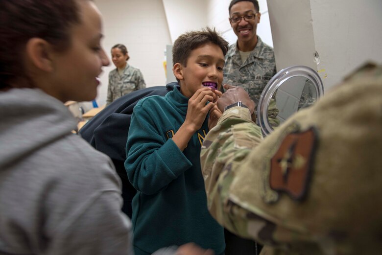 A student looks in the mirror for tooth plaque during a visit from the 49th Operational Readiness Medical Squadron Dental Flight, Feb. 26, 2020, at Holloman Middle School on Holloman Air Force Base, N.M. Between dental visits it’s recommended to check for tooth sensitivity, pain when eating or drinking, bleeding gums, holes or pits in teeth, discoloration or bad breath. (U.S. Air Force photo by Staff Sgt. Christine Groening)
