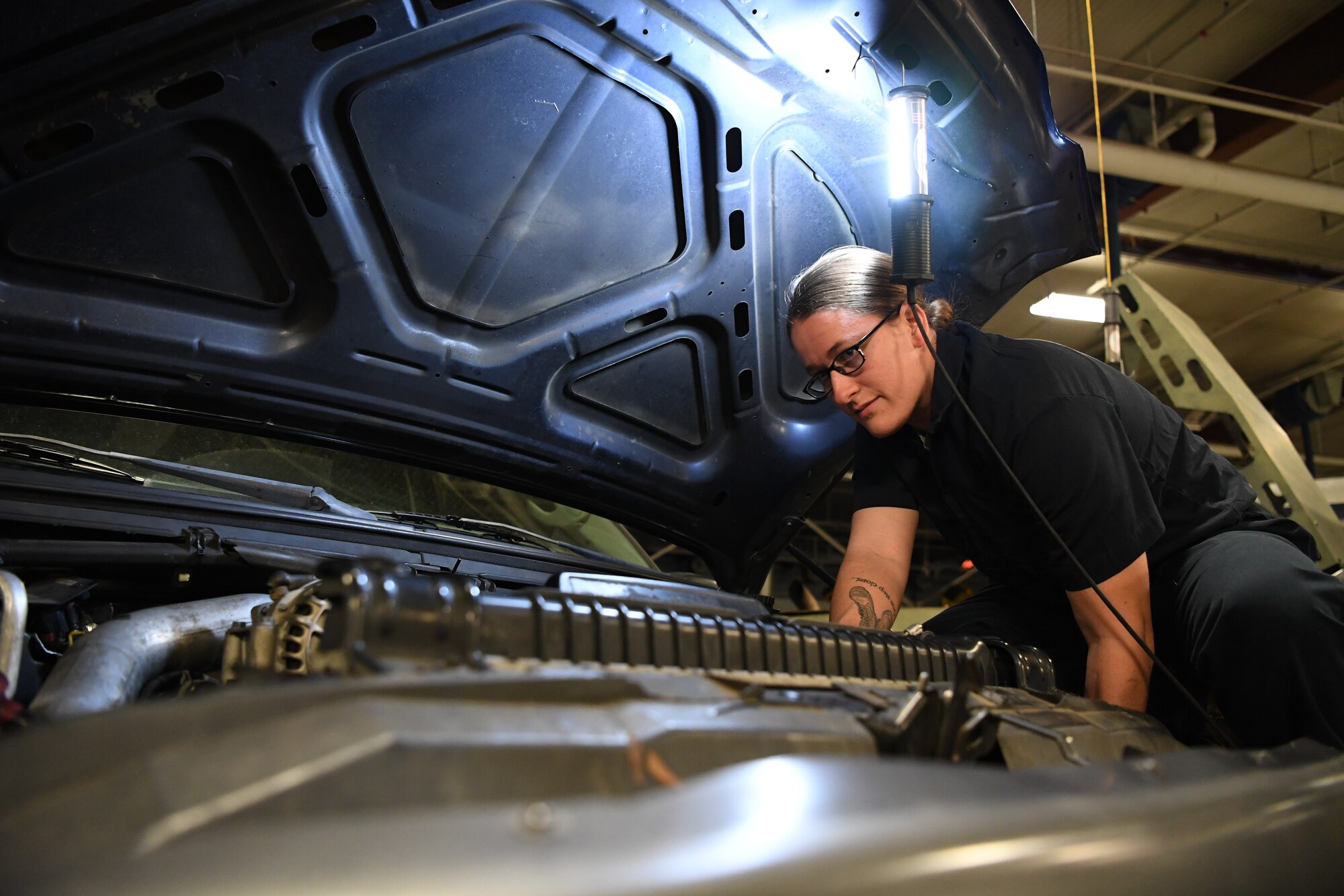 Photo of Airman working on vehicle.