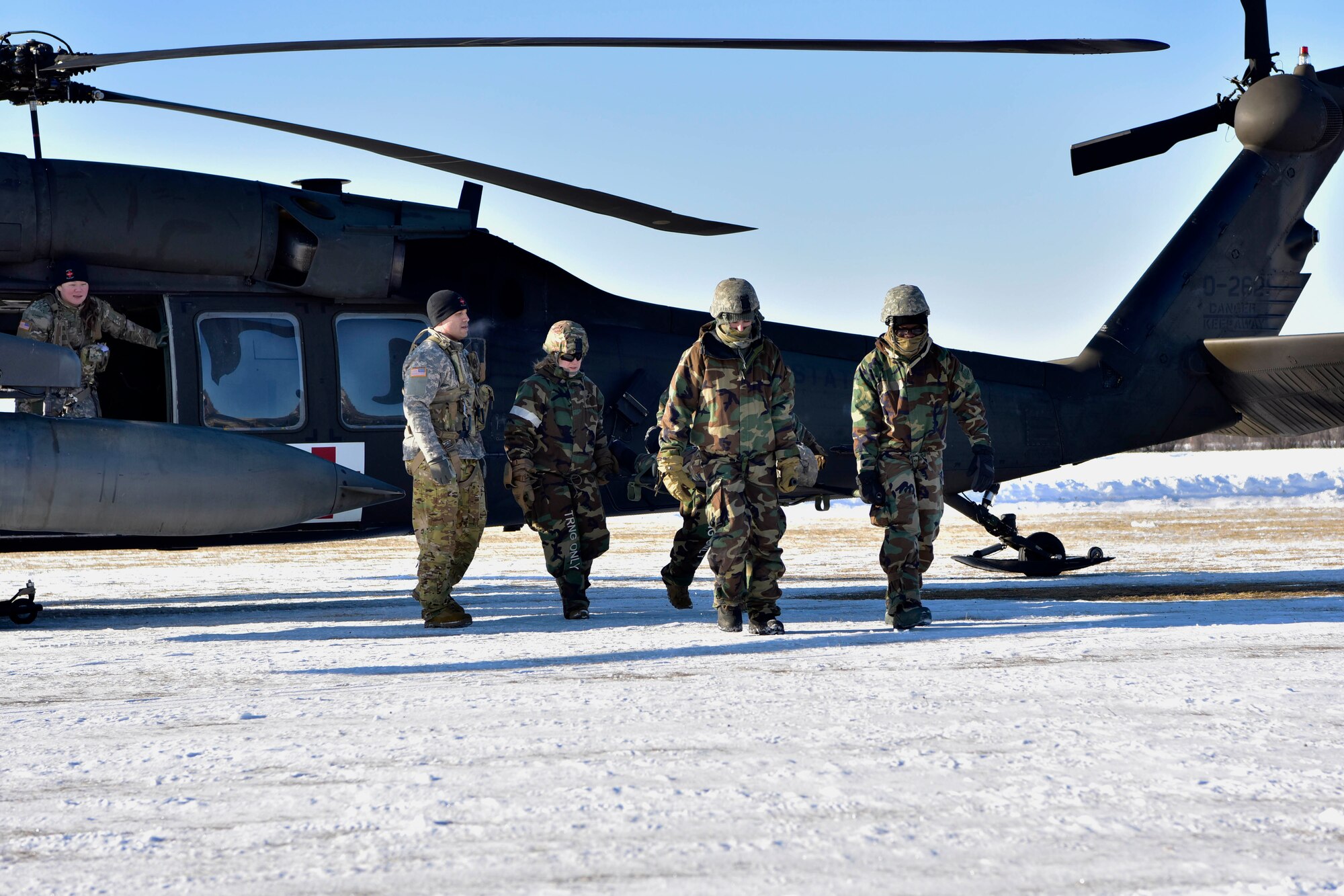 A U.S. Army Soldier teaches 354th Security Forces Squadron (SFS) defenders how to properly remove a casualty from a UH-60 Blackhawk during a medical evacuation (MEDEVAC) exercise on Eielson Air Force Base, Alaska, Feb. 26, 2020. The 354th SFS partnered with 1-52D General Support Aviation Battalion to be able to simulate a real world MEDEVAC. (U.S. Air Force photo by Senior Airman Beaux Hebert)