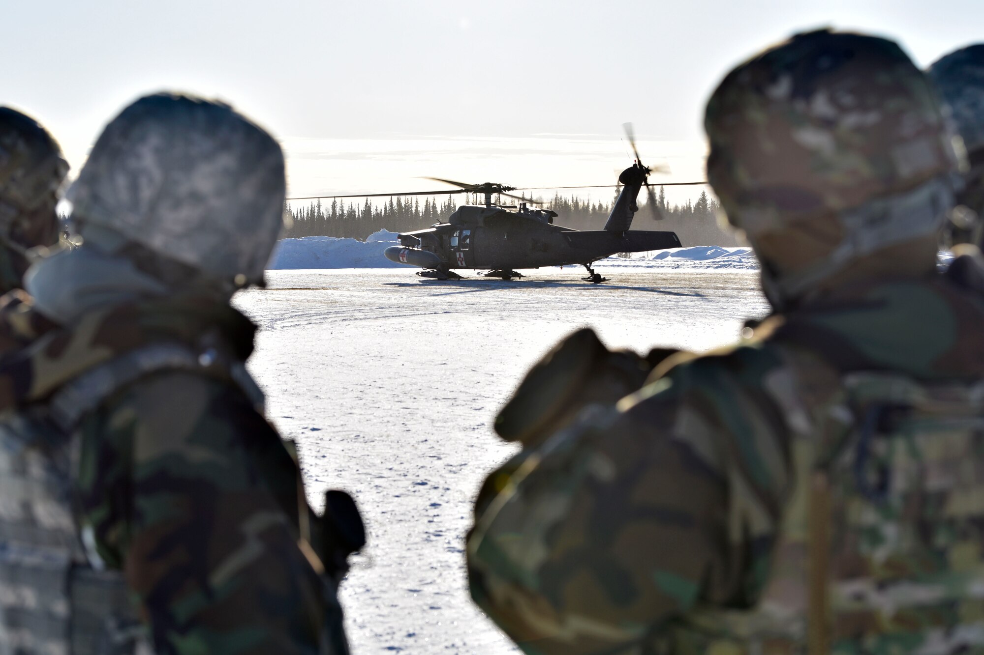 354th Security Forces Squadron defenders observe a UH-60 Blackhawk during a medical evacuation exercise on Eielson Air Force Base, Alaska, Feb. 26, 2020. Defenders loaded a simulated casualty into the aircraft and rode in the Blackhawk to familiarize themselves with the aircraft. (U.S. Air Force photo by Senior Airman Beaux Hebert)