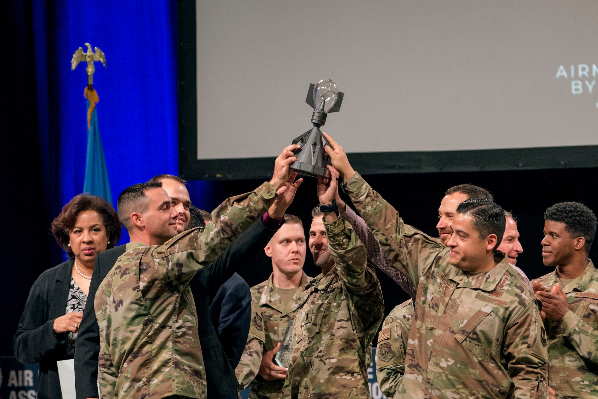 Airmen share the Spark Tank trophy after Air Force and industry leaders declared a two-way tie at the Air Force Association's Air Warfare Symposium, in Orlando, Fla., Feb. 28, 2020. The three-day event is a professional development forum that offers the opportunity for Department of Defense personnel to participate in forums, speeches, seminars and workshops with defense industry professionals. (U.S. Air Force photo by Staff Sgt. James Richardson)