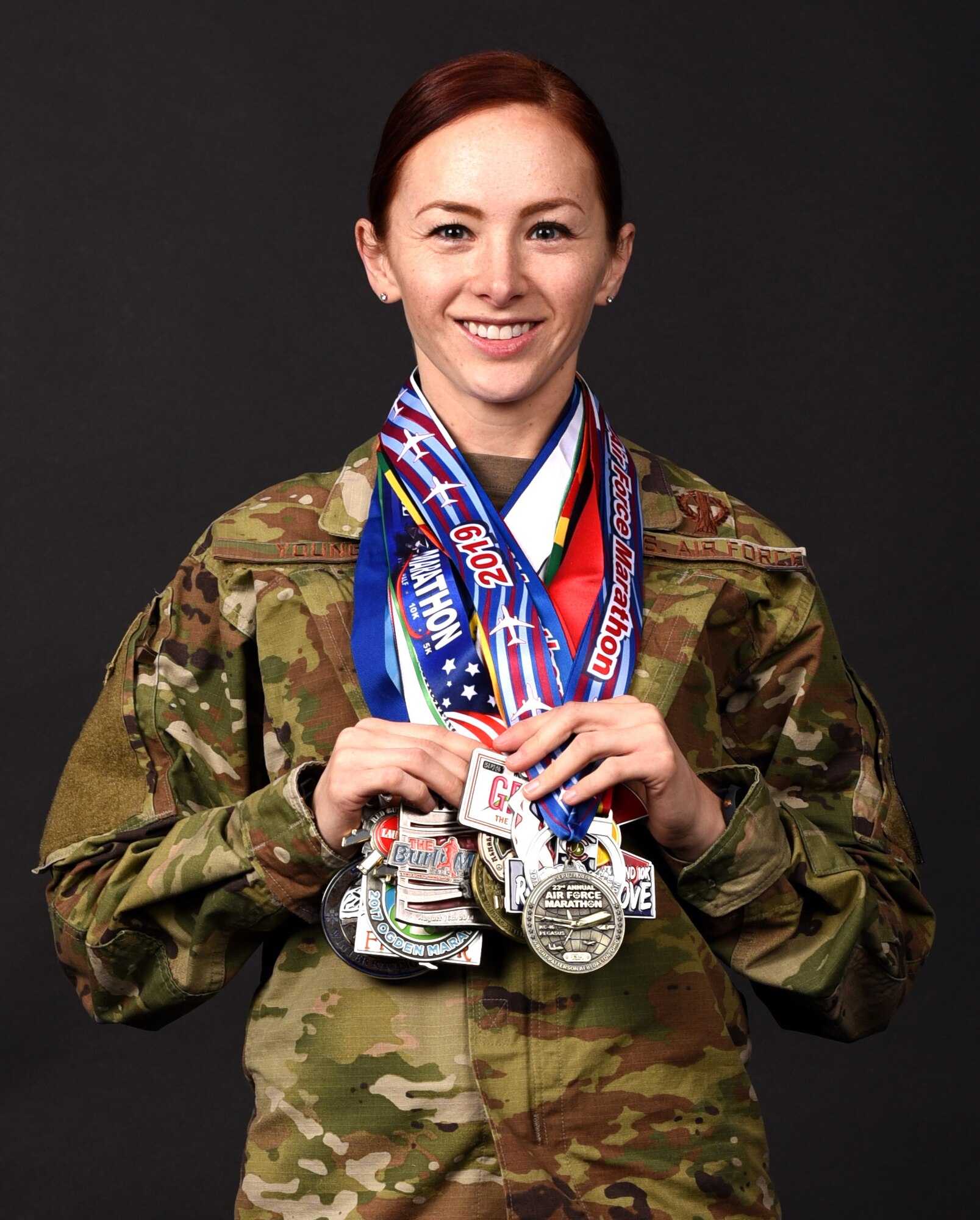 Capt Mary Young poses for a photo with her medals from marathons