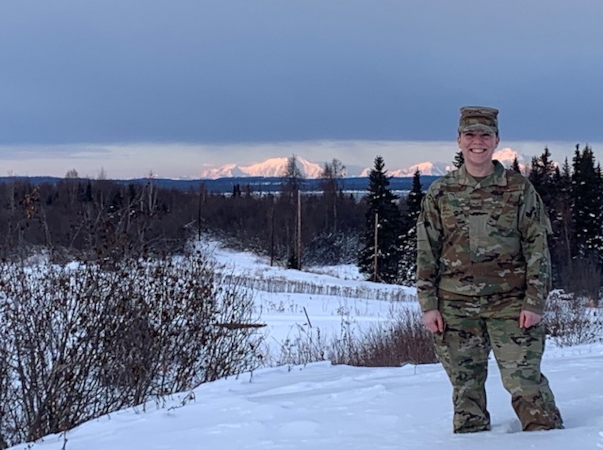 Air Force Senior Airman Alaina Armentrout poses for the camera with Denali in the background, January 30, 2020 at Joint Base Elmendorf-Richardson, Alaska. Armentrout is assigned to the 381st Intelligence Squadron as a cryptologic language analyst.