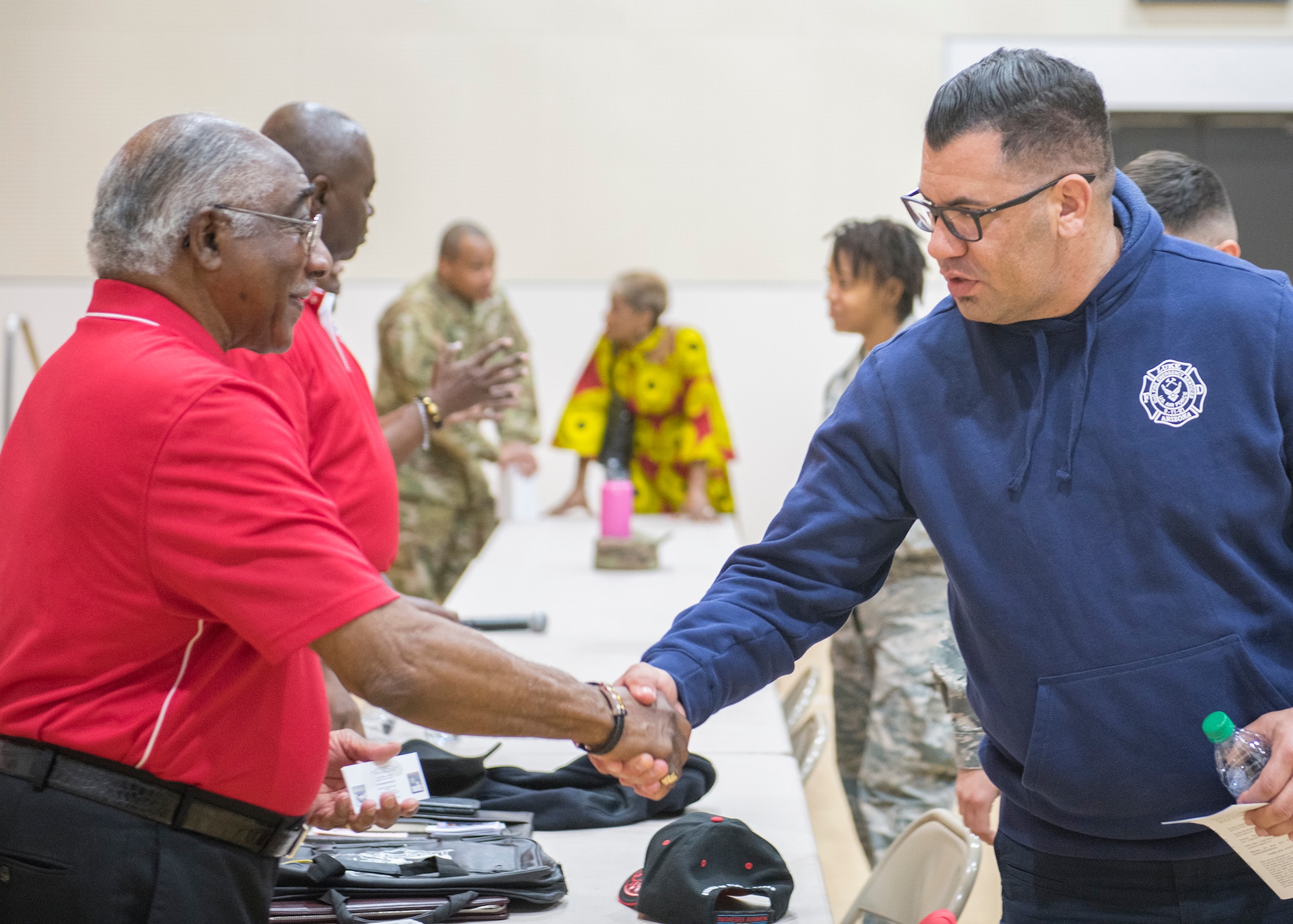 Retired U.S. Air Force Col. Richard Toliver, member of the Archer-Ragsdale Arizona chapter of Tuskegee Airmen Incorporated, shakes Tracy McGregor’s hand, 56th Civil Engineer Squadron fire and emergency services, after a Black History Month panel discussion Feb. 27, 2020, at Luke Air Force Base, Ariz.