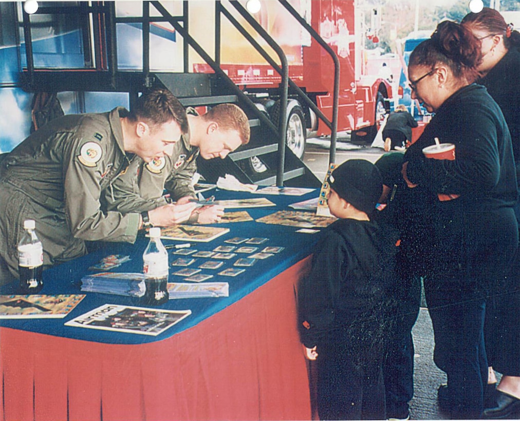 From left, U.S. Air Force Capts Britt Hatley and Capt. Jeffery Schreiner, 393rd Bomb Squadron pilots, sign B-2 Spirit Stealth Bomber lithographs at the Air Force Experience and Air Force recruiting demonstration, for the Rose Bowl’s Fan Fest attendees in Pasadena, California, Jan. 1, 2002.