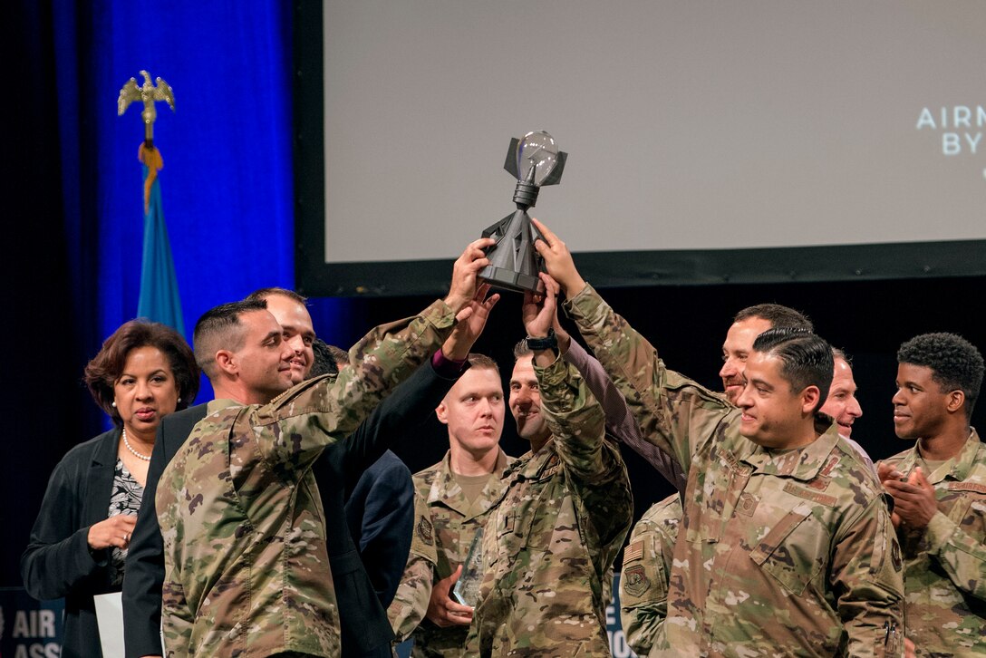 Airmen share the Spark Tank trophy after Air Force and industry leaders declared a two-way tie at the Air Force Association's Air Warfare Symposium, in Orlando, Fla., Feb. 28, 2020. The three-day event is a professional development forum that offers the opportunity for Department of Defense personnel to participate in forums, speeches, seminars and workshops with defense industry professionals. (U.S. Air Force photo by Staff Sgt. James Richardson)