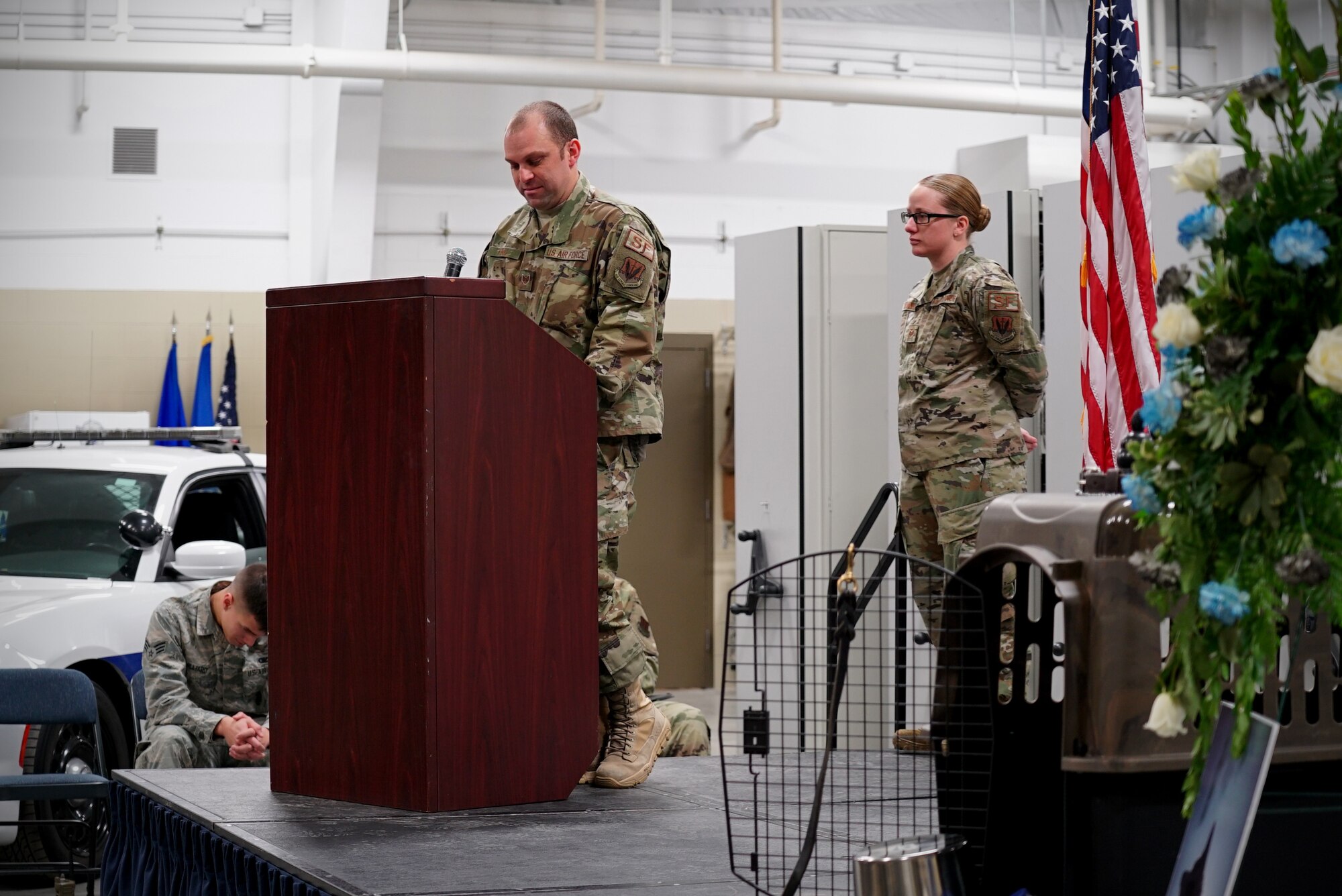 Staff Sgt. Sean King, 319th Security Forces Squadron military working dog handler, left, speaks during a memorial service Dec. 20, 2019, on Grand Forks Air Force Base, North Dakota. The memorial service honored the life of King’s partner, military working dog, “Dex.”  (U.S. Air Force photo by Senior Airman Elora J. Martinez)