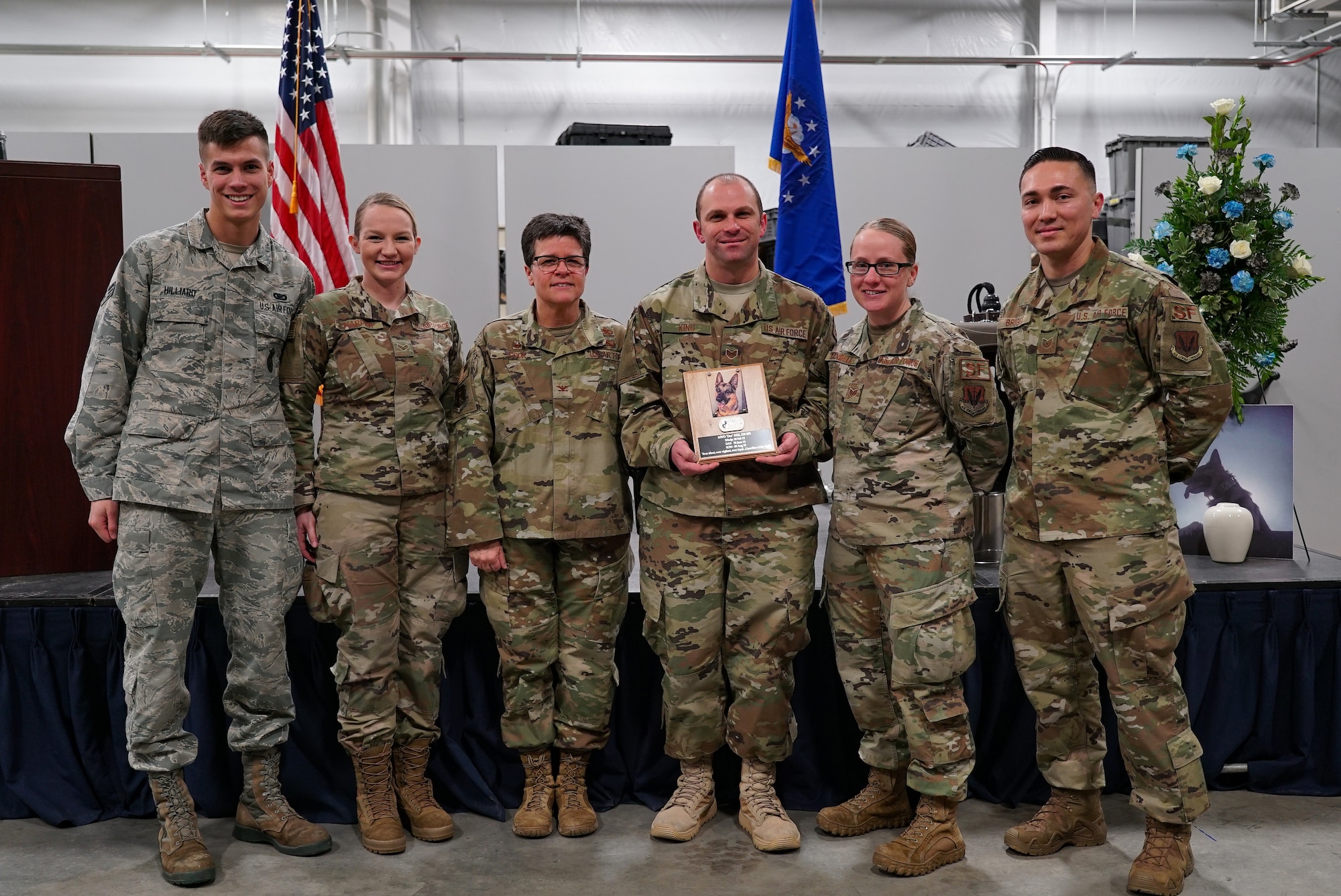 Military working dogs with the 319th Security Forces Squadron stand with Col. Heather Cook, 319th Mission Support Group commander, center left, following a military working dog memorial service Dec. 20, 2019, on Grand Forks Air Force Base, North Dakota. The 319 SFS honored the life of “Dex,” a narcotic detector dog who served for five years on Grand Forks AFB. (U.S. Air Force photo by Senior Airman Elora J. Martinez)