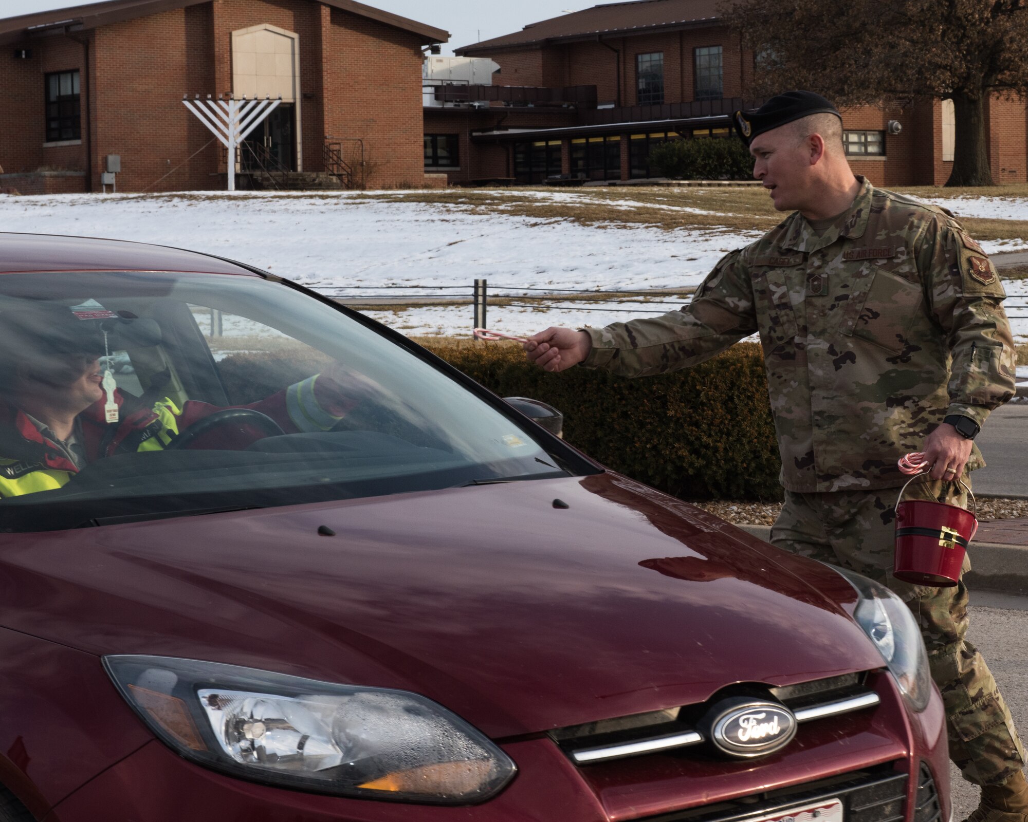 U.S. Air Force Chief Master Sgt. Joseph Casey, 509th Security Forces Squadron manager, gives a candy cane to a member of Whiteman on Dec. 20, 2019, at Whiteman Air Force Base, Missouri. Casey and other chief master sergeants took the opportunity to strengthen connections by handing out candy canes and wishing Whiteman Airmen and families a happy holiday. (U.S. Air Force photo by Airman 1st Class Christina Carter)