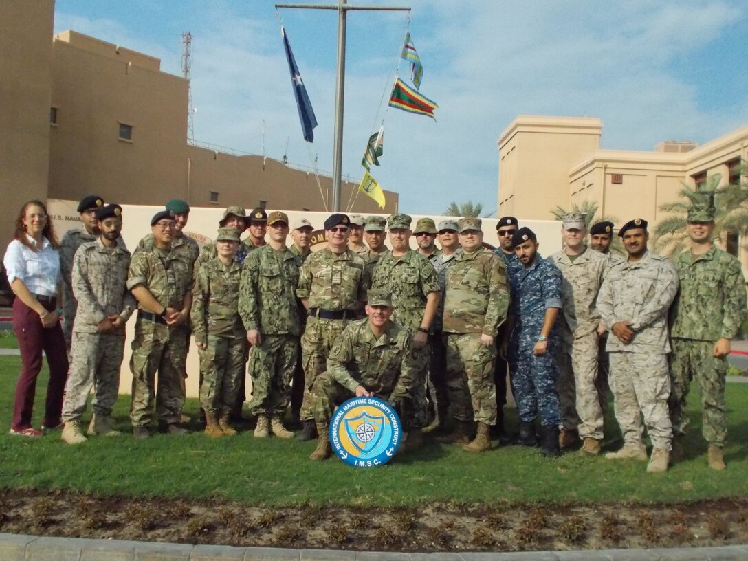 U.S. Army Reserve Col. John Conklin, center, poses for a photo with service members and a DoD civilian from the Joint Planning Support Element and members of the International Maritime Security Construct in front of the Combined Maritime Forces Headquarters, Naval Support Activity, Bahrain, Nov. 25, 2019.