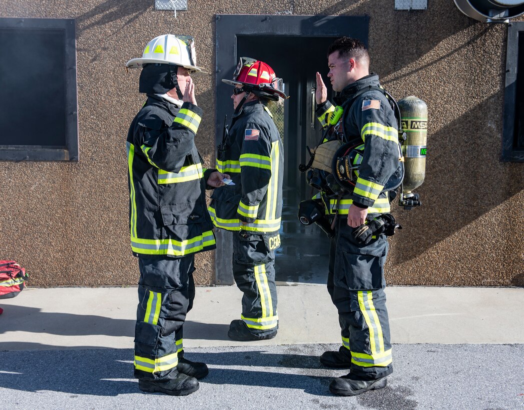 U.S. Air Force Col. Brian Laidlaw, 325th Fighter Wing commander (left), reads the Oath of Enlistment to U.S. Air Force Senior Airman Christian Gosnell, 325th Civil Engineer Squadron driver operator (right), after a simulated burning building exercise at Tyndall Air Force Base, Fla., Dec. 20, 2019. Gosnell was selected to have the wing commander come out and have a hands on experience with his job at the fire department. (U.S. Air Force photo by Senior Airman Stefan Alvarez)