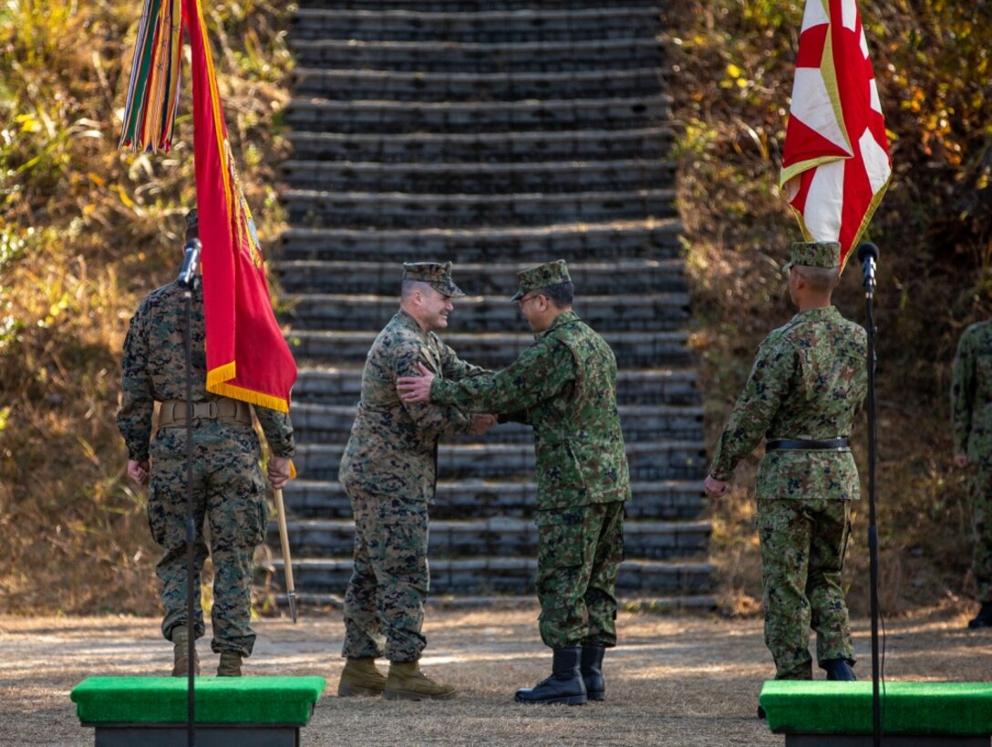 U.S. Marine Lt. Col. Clinton Cummings, commanding officer of 1st Battalion, 25th Marine Regiment, currently assigned to 4th Marine Regiment, 3rd Marine Division, under the Unit Deployment Program, shakes hands with Col. Akamai Kazuo, commanding officer of 8th Infantry Regiment, Japan Ground Self-Defense Force, at an opening ceremony during Forest Light Middle Army in Aibano Training Area, Shiga, Japan, Dec. 1, 2019. Forest Light Middle Army is an annual training exercise that is designed to enhance the collective defense capabilities of the United States and Japan Alliance by allowing infantry units to maintain their lethality and proficiency in infantry and combined arms tactics. (U.S. Marine Corps photo by Lance Cpl. D’Angelo Yanez)