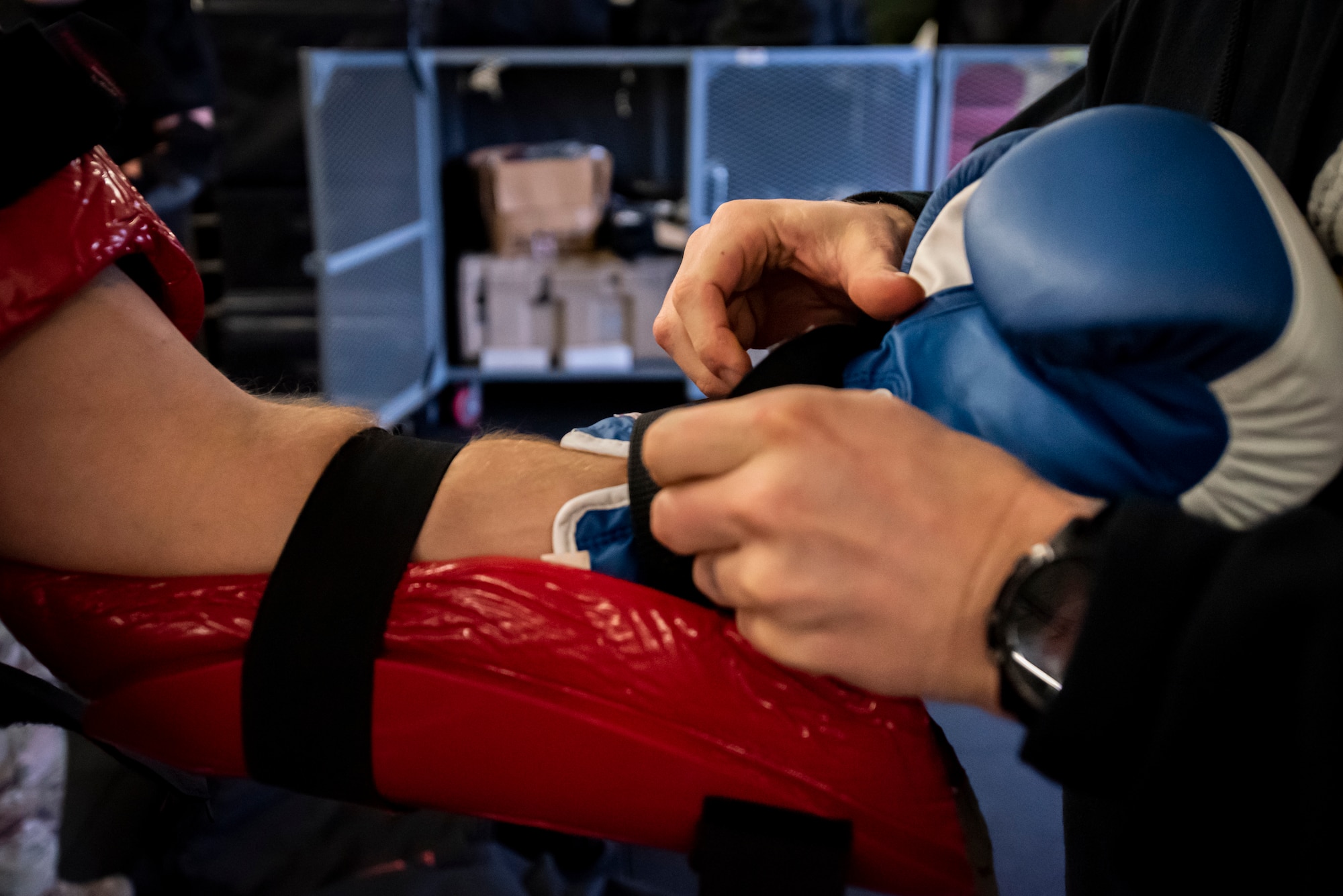 A U.S. Air Force Airman straps a boxing glove onto another Airman’s wrist during a Leader Led Training Course at Ramstein Air Base, Germany, Dec. 7, 2019. During the course, Airmen sparred against each other in “RedMan” protective gear to learn how to use advanced fighting techniques. (U.S. Air Force photo by Staff Sgt. Devin Nothstine)