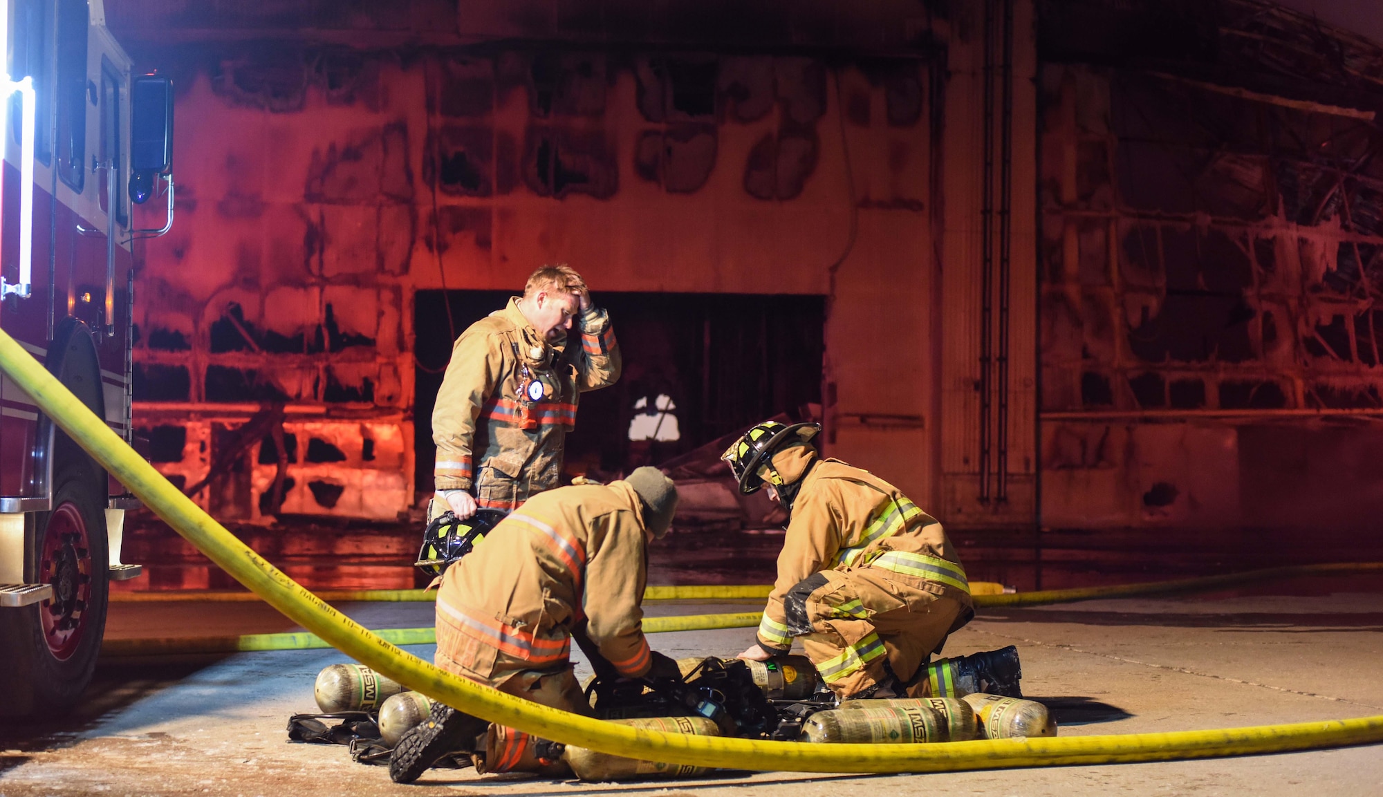 Firefighters assess the situation of the scene Dec. 28, 2019, at Minot Air Force Base, North Dakota. These Airmen are trying to decide the best way to attack the fire. (U.S. Air Force Photos By Airman 1st Class Caleb S. Kimmell)
