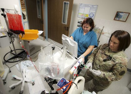 Army Maj. Julie Duffy (right), clinical nurse specialist, Intensive Care Unit, Landstuhl Regional Medical Center, prepares a cycler used for Continuous Renal Replacement Therapies as Petra Wine, critical care nurse, provides instruction during CRRT training at LRMC's ICU Dec. 19, 2019.