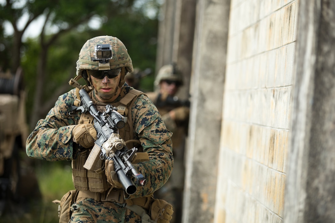Lance Cpl. Tyler Munkvold, a rifleman with Alpha Company, Battalion Landing Team, 1st Battalion, 5th Marines, 31st Marine Expeditionary Unit, prepares to clear a building during a simulated raid of a town at the Central Training Area, Okinawa, Japan, on Dec. 9.