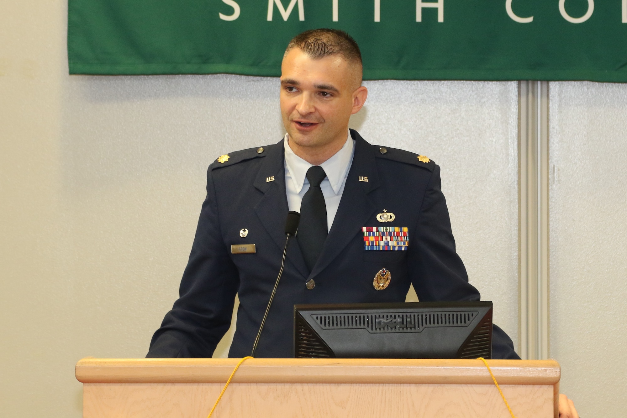 An Airman stands a podium and gives a speech