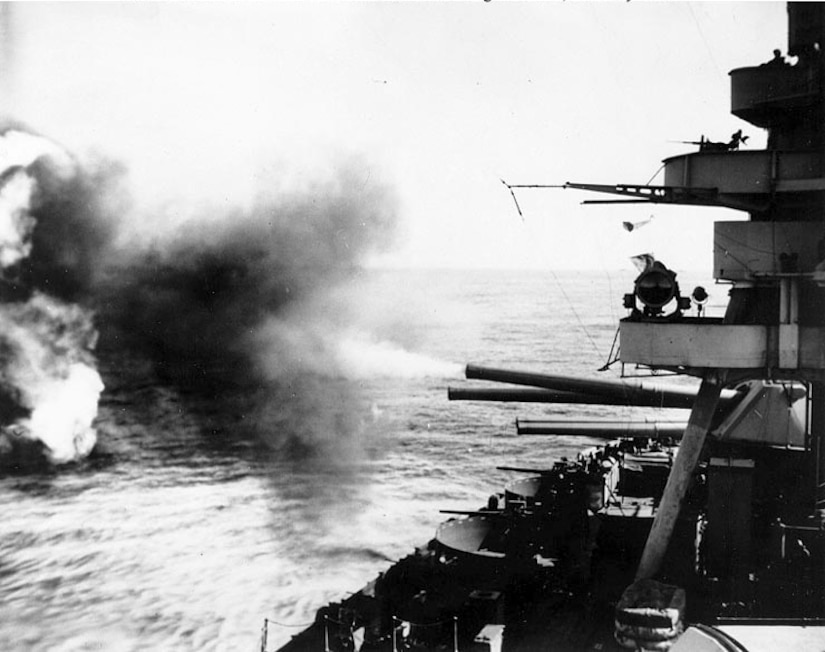 A battleship fires guns.